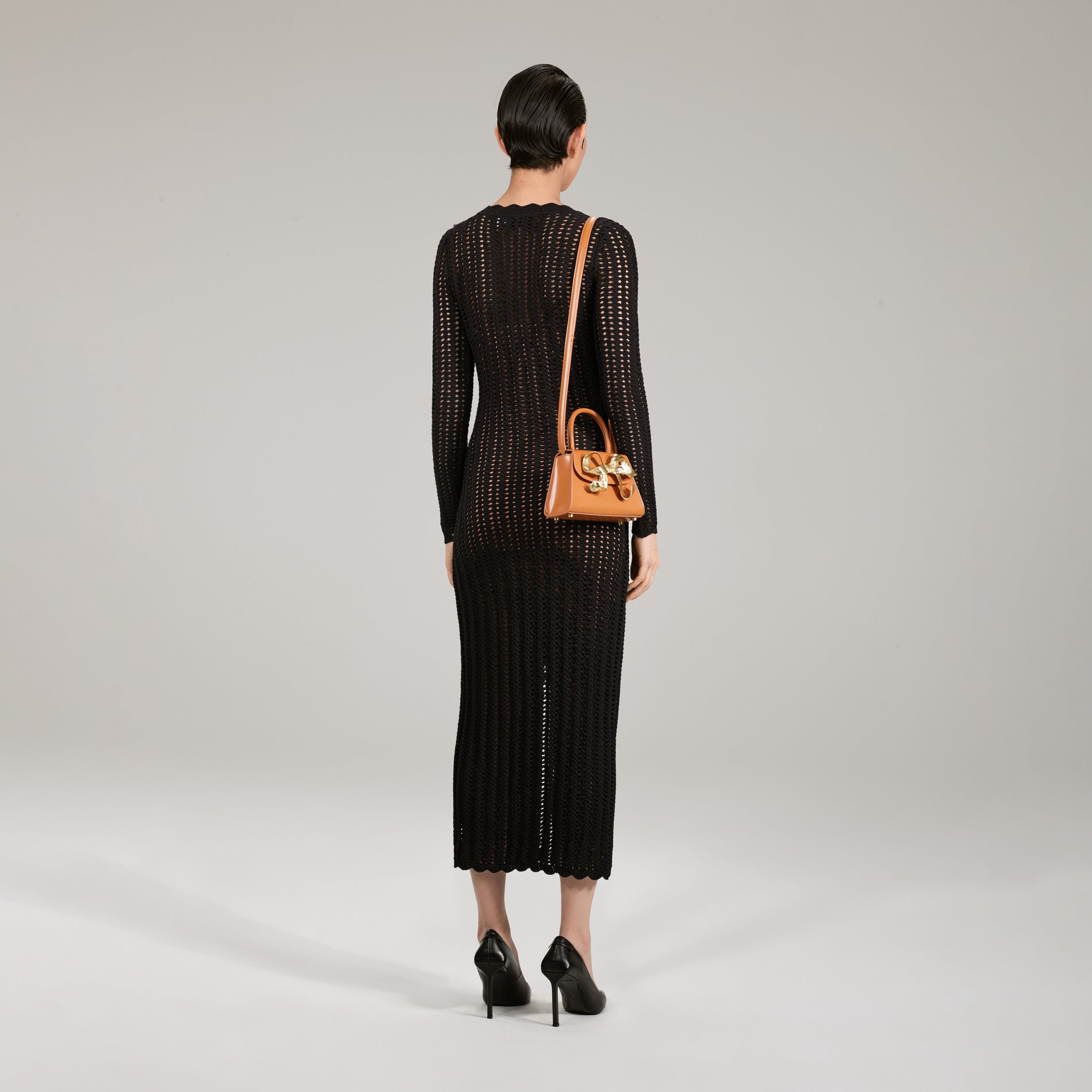 A woman wearing the Black Crochet Knit Dress