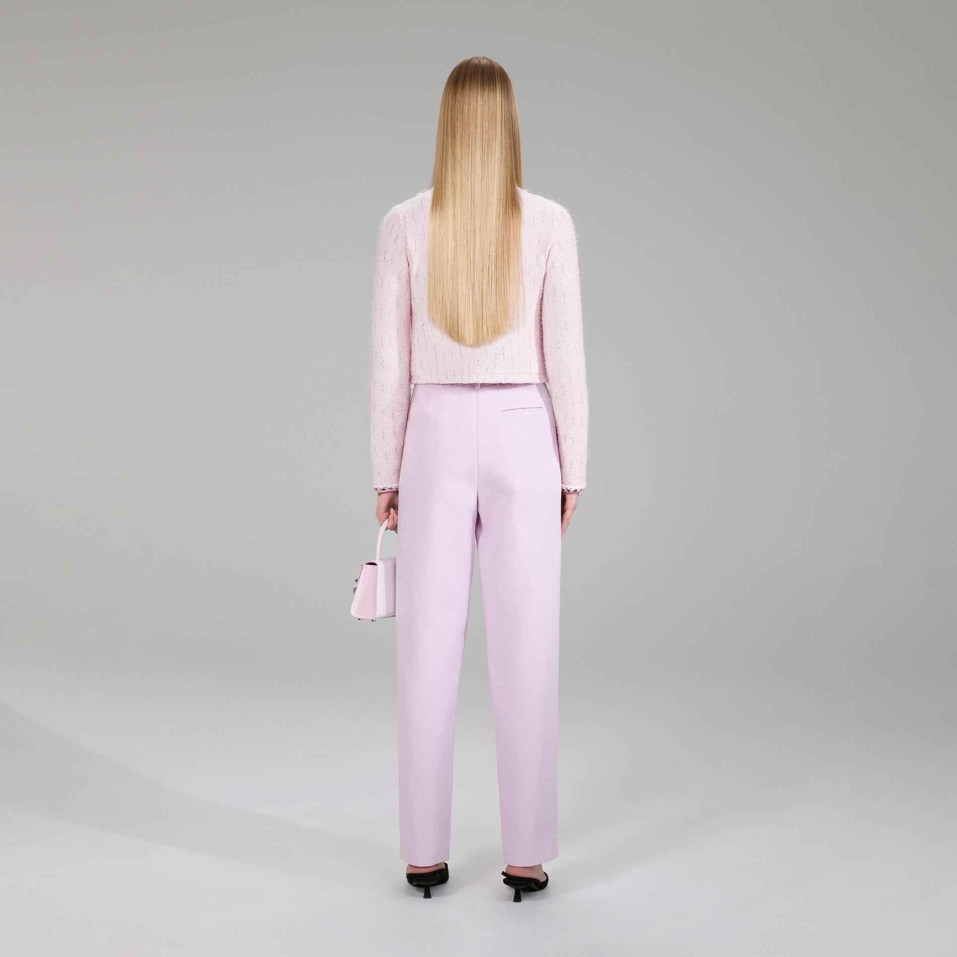 A woman wearing the Pink Melange Knit Cardigan