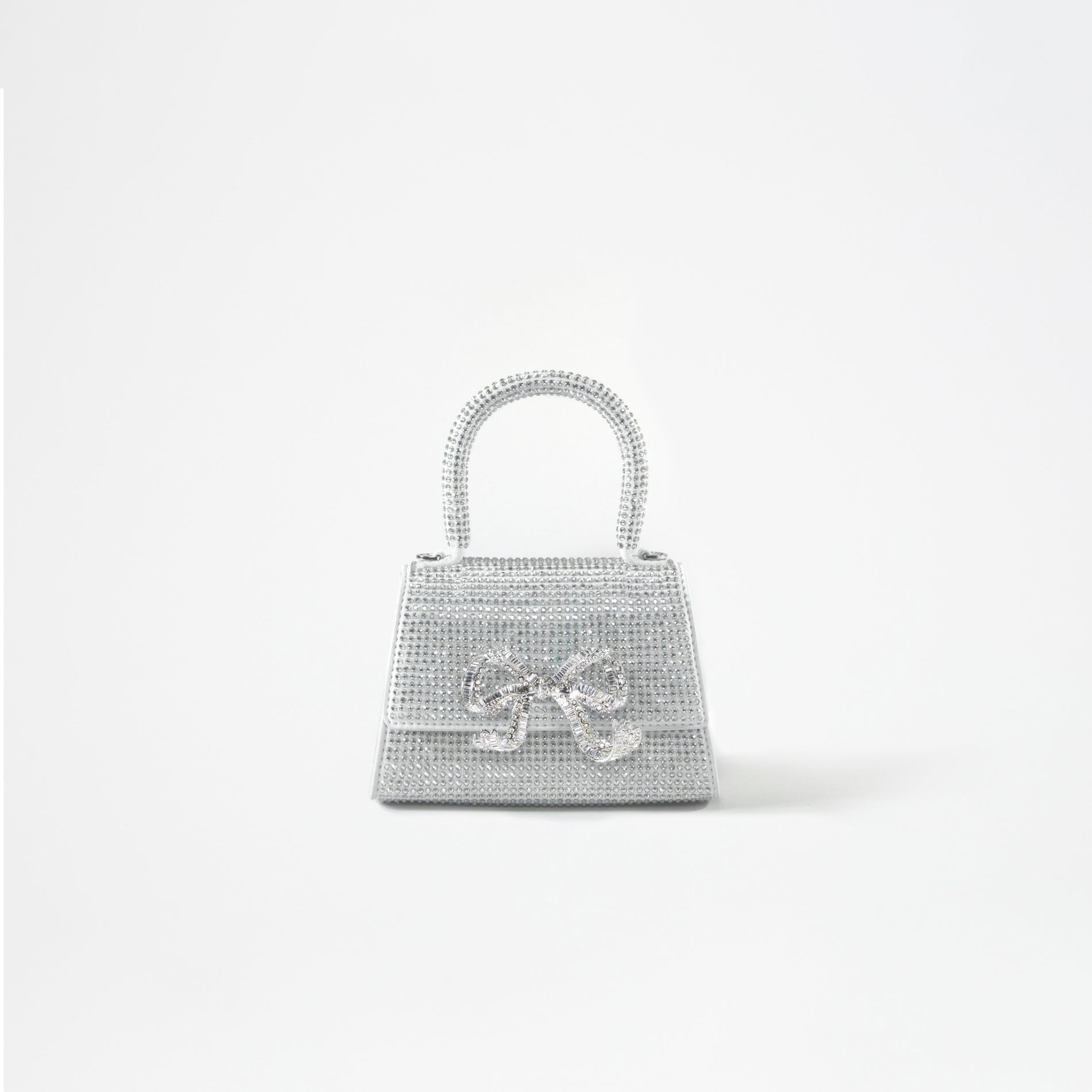 A woman wearing the Silver Rhinestone Bow Micro Bag