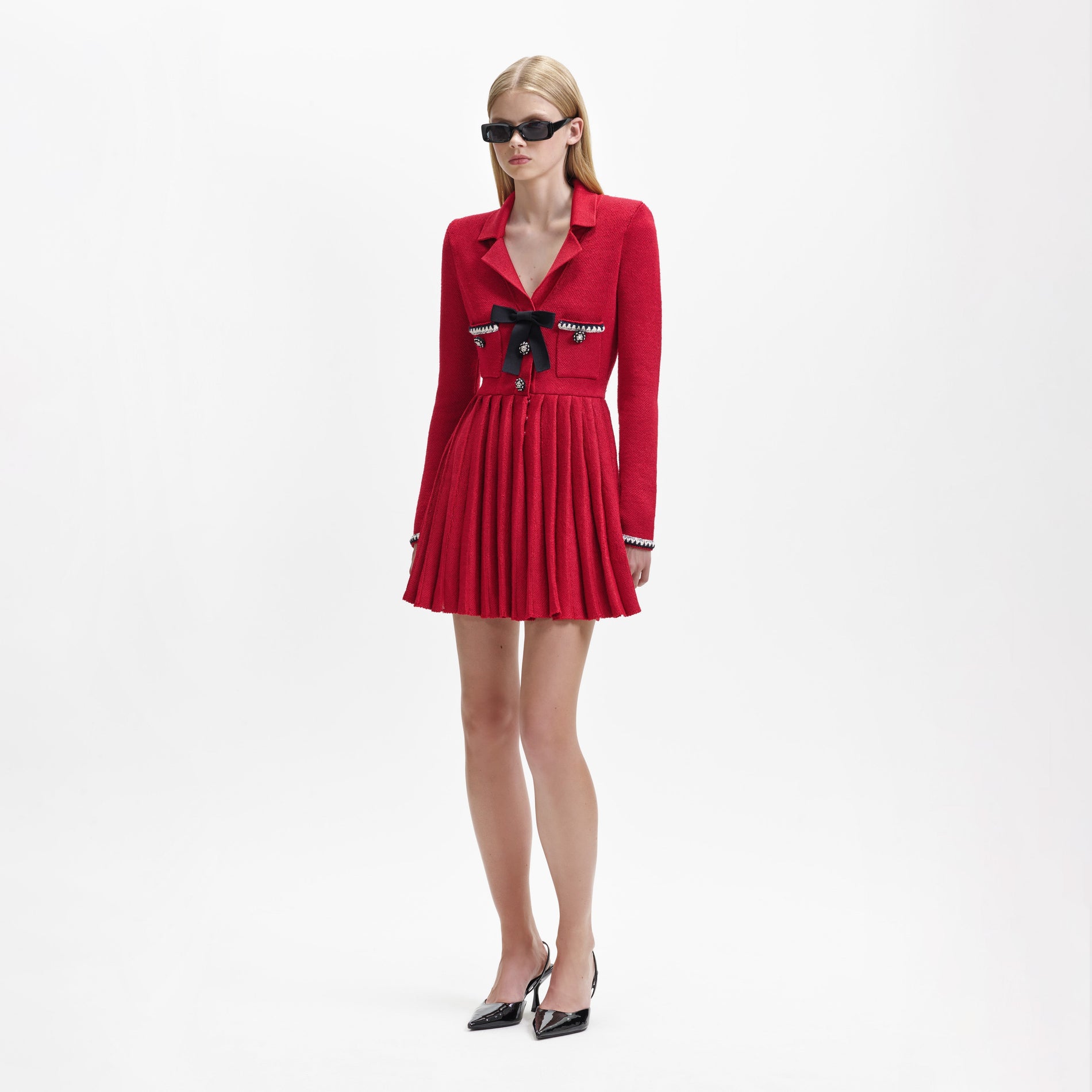 Side view of a woman wearing the Red Knit Bow Mini Dress