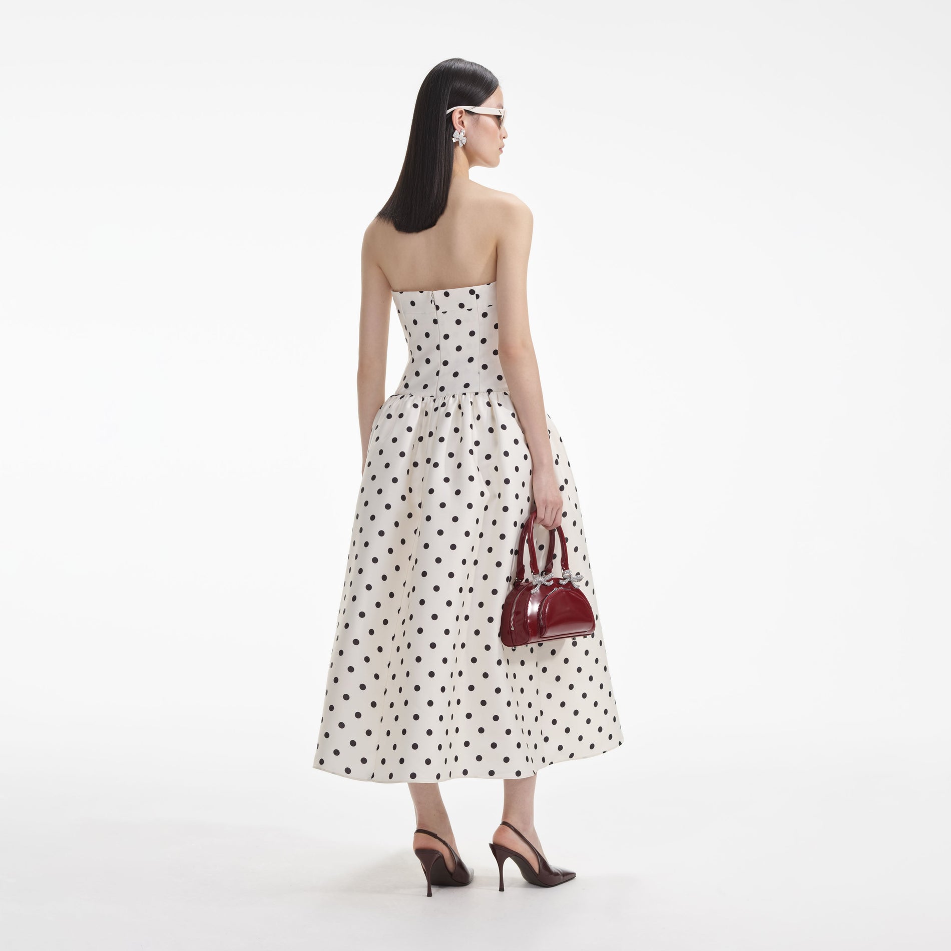 A close up of a woman wearing the Cream Polka Dot Taffeta Midi Dress