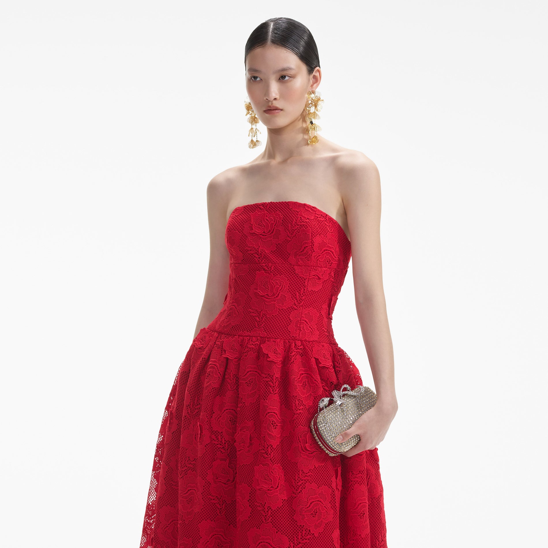 A close up of a woman wearing the Gold Floral Earrings