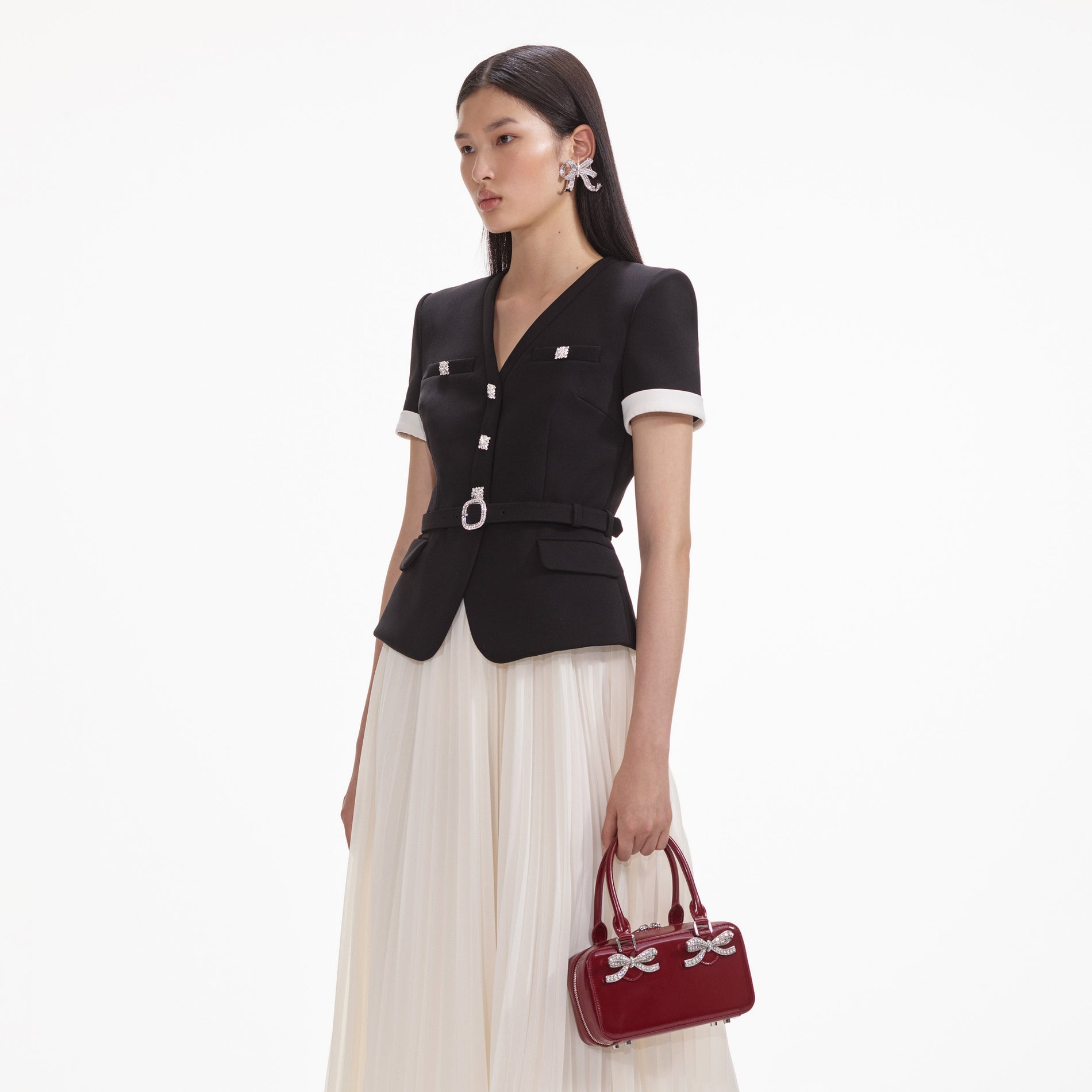 A close up of a woman wearing the Crystal Bow Earrings