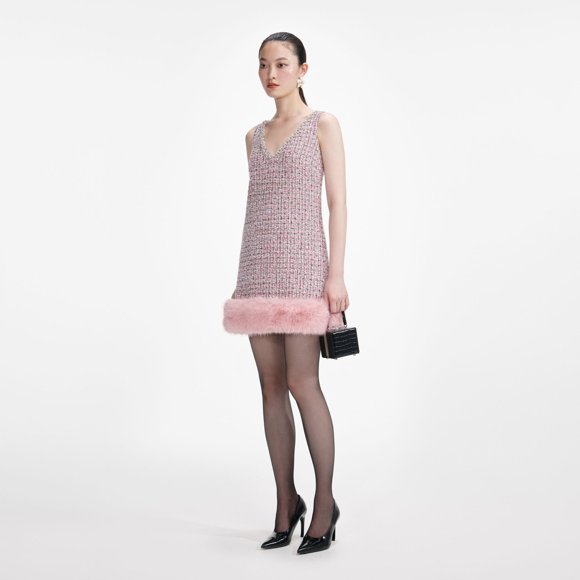 Side view of a woman wearing the Pink Boucle Fur Hem Mini Dress