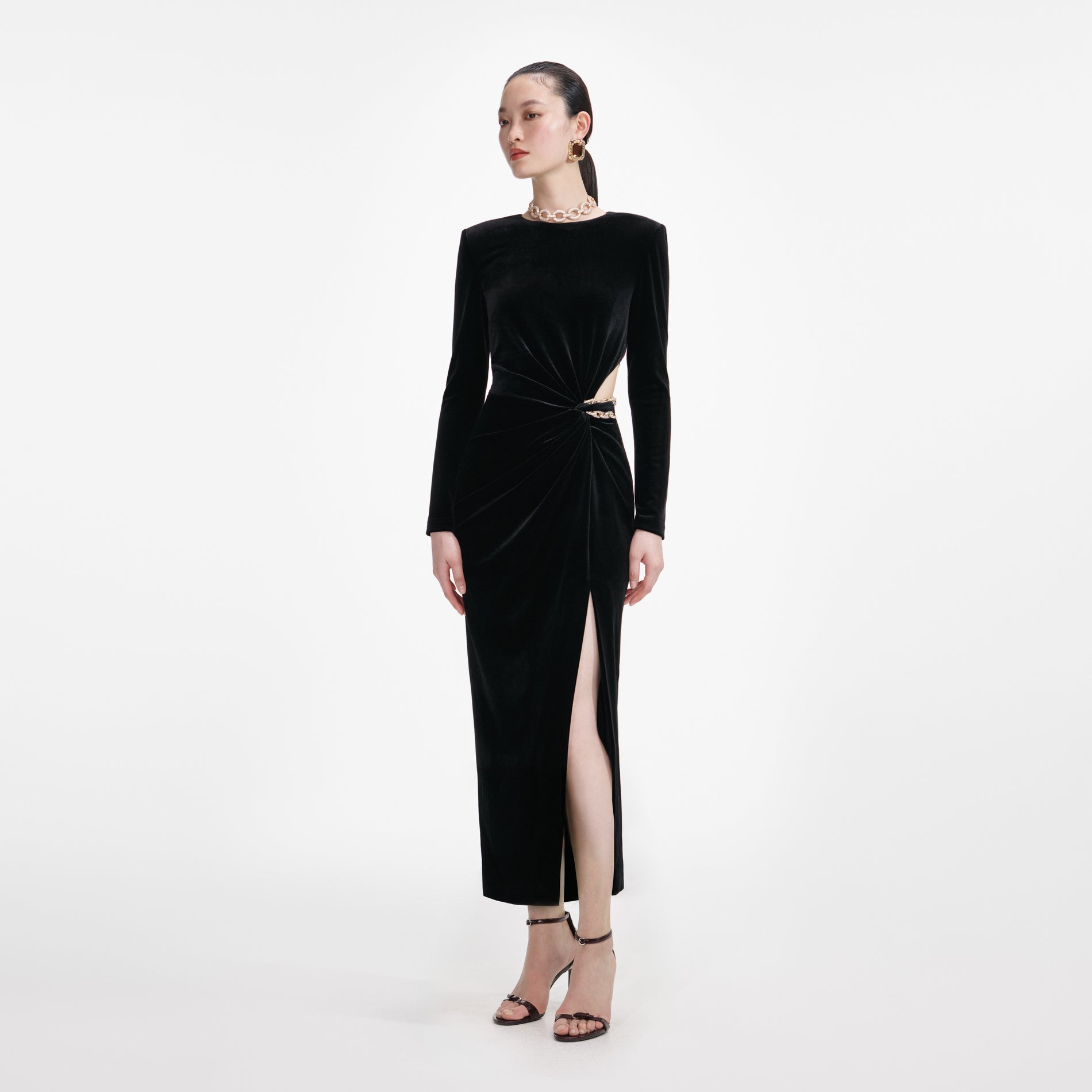 Side view of a woman wearing the Black Velvet Embellished Midi Dress