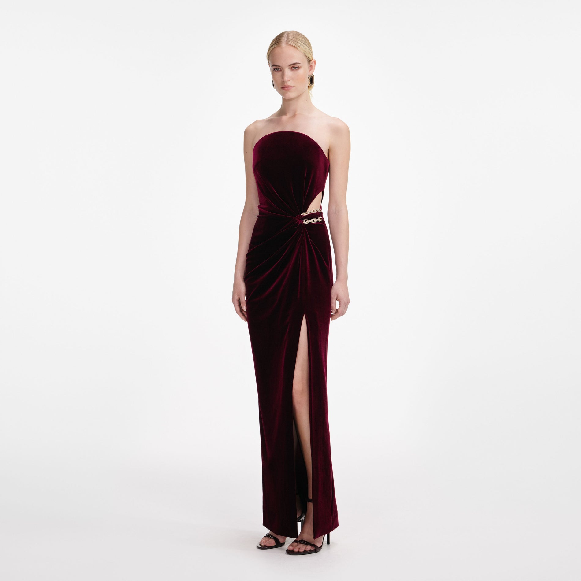 Side view of a woman wearing the Burgundy Velvet Bandeau Maxi Dress