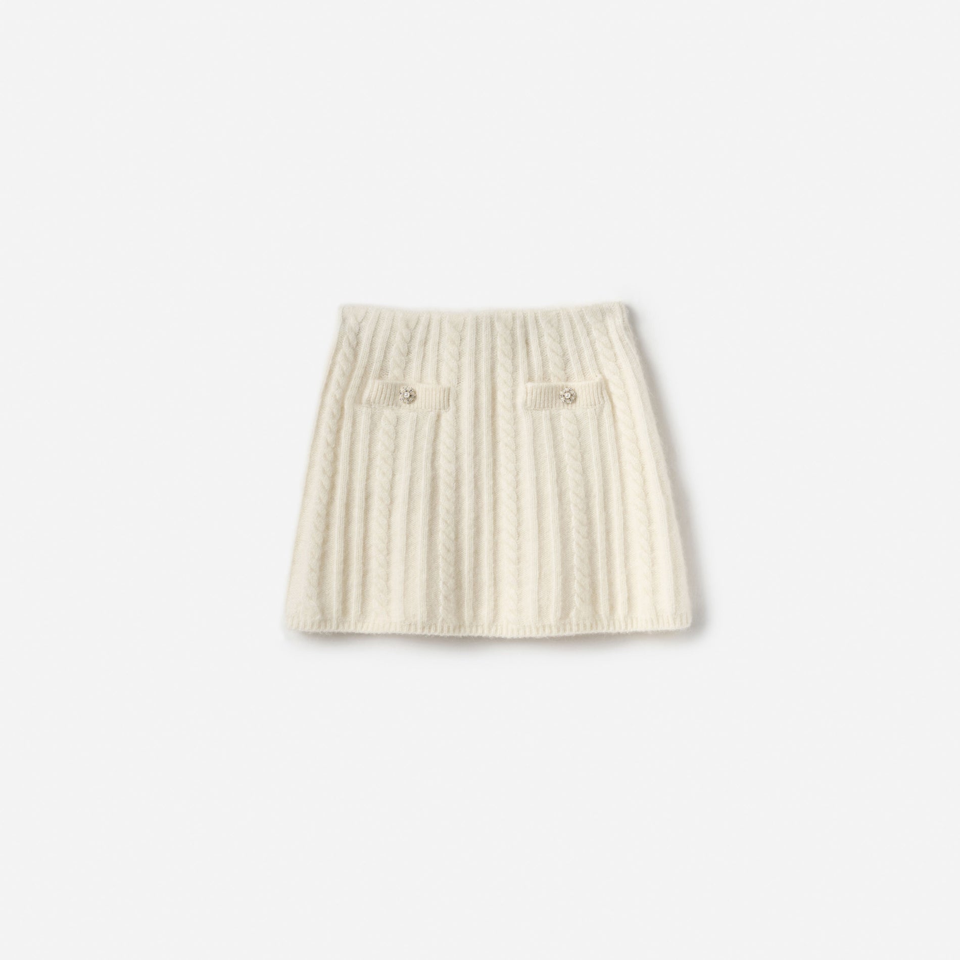 Cream cable knit mini skirt with two front pockets and decorative buttons