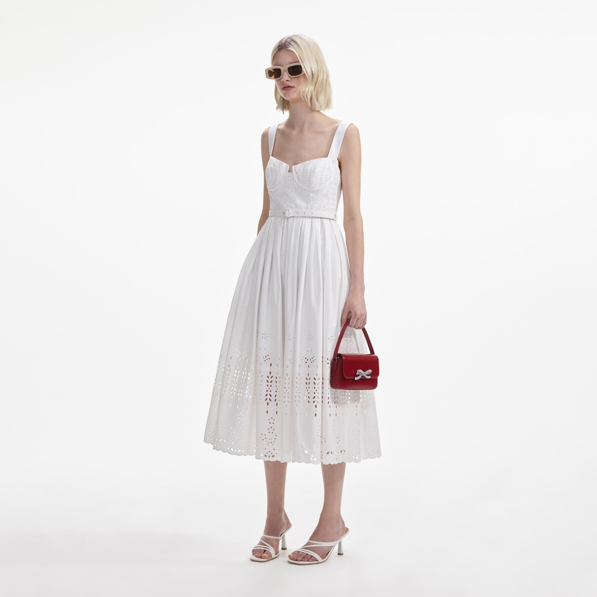 Side view of a woman wearing the White Cotton Broderie Midi Dress
