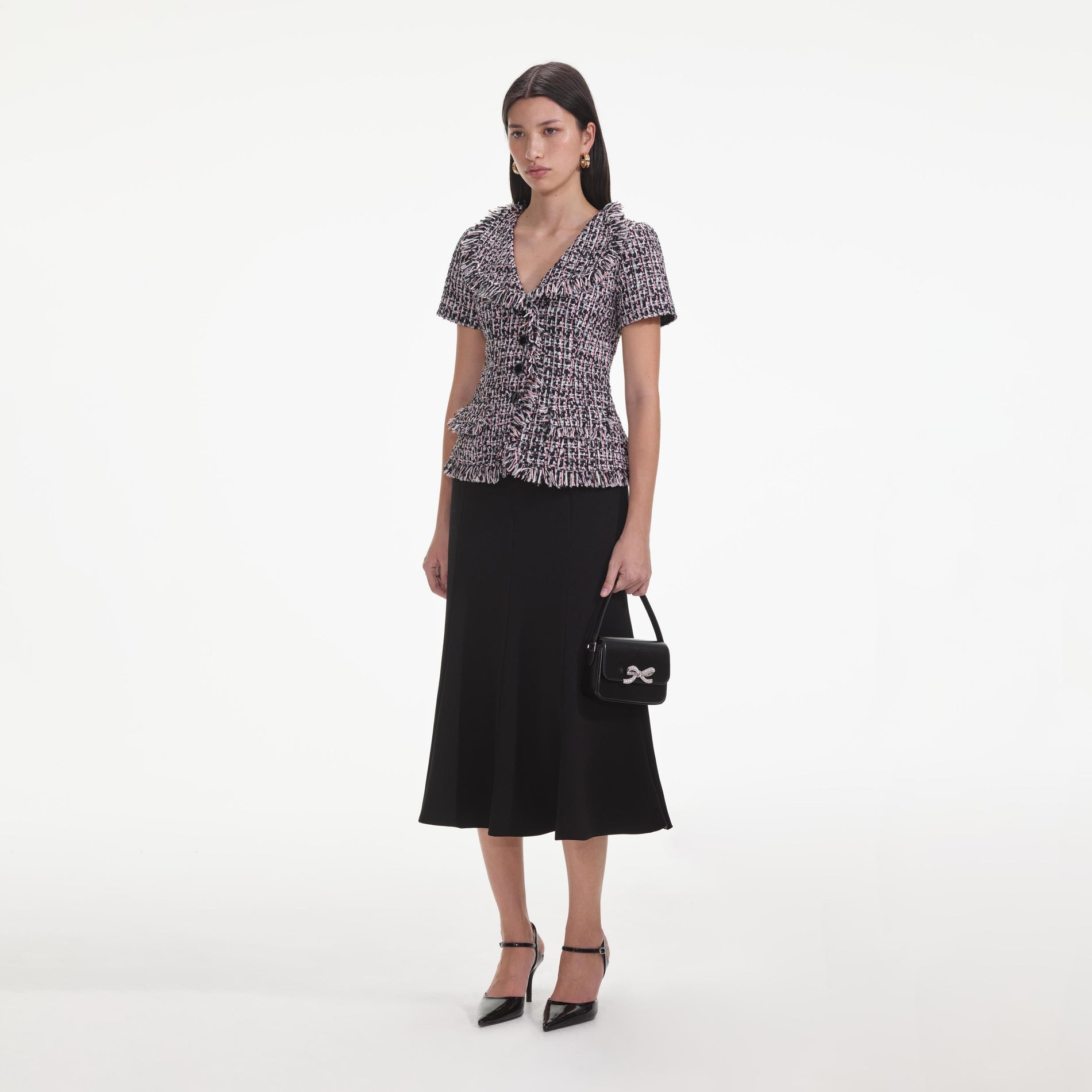 Side view of a woman wearing the Black Boucle Fringed Midi Dress