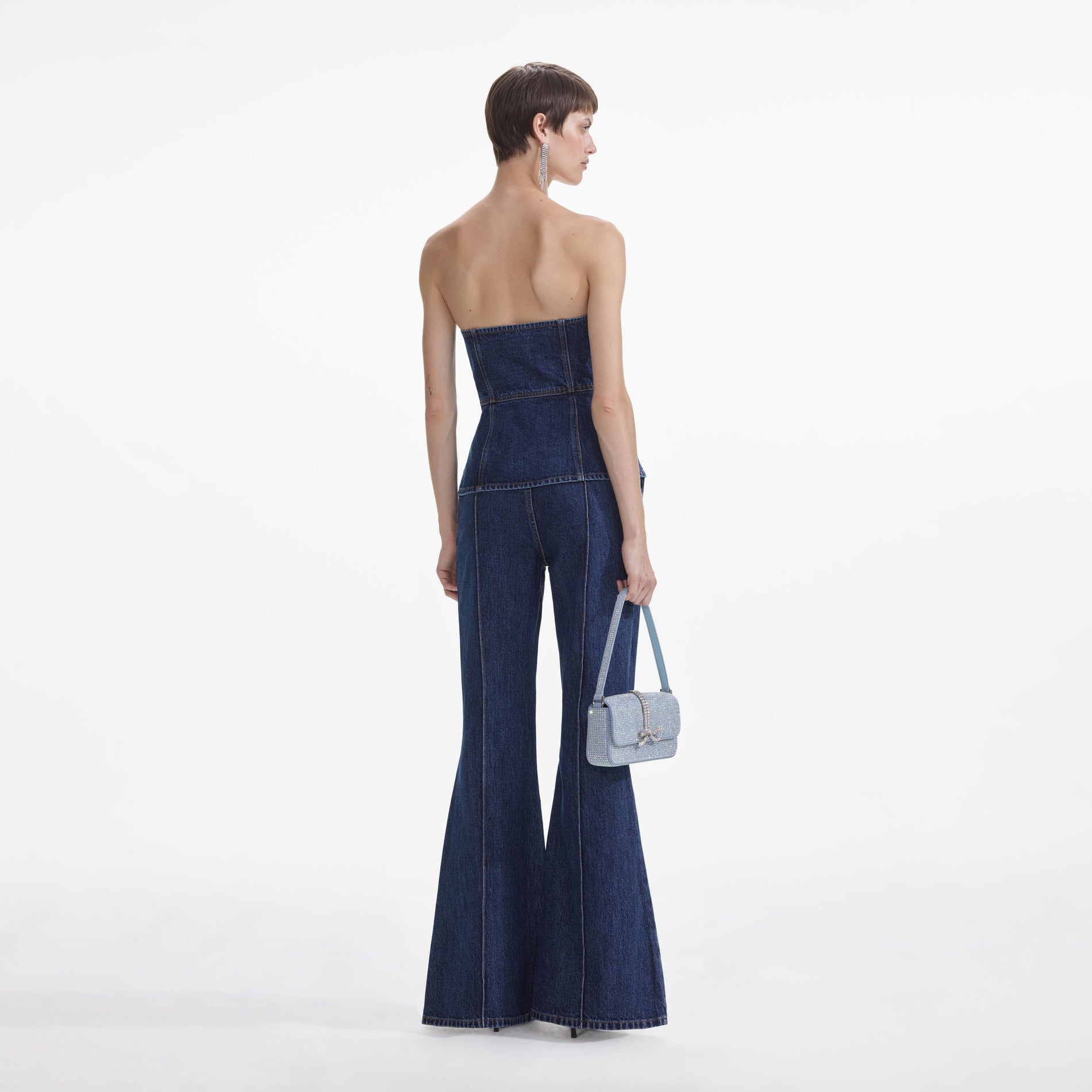 Back view of a woman wearing the Denim Bandeau Jumpsuit
