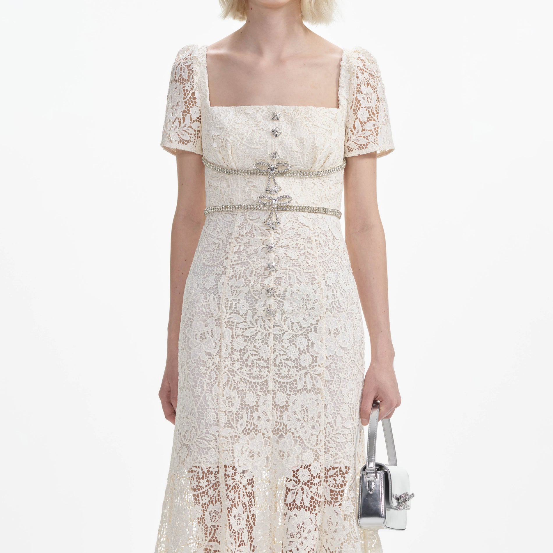 A close up of a woman wearing the Cream Lace Diamante Bow Midi Dress