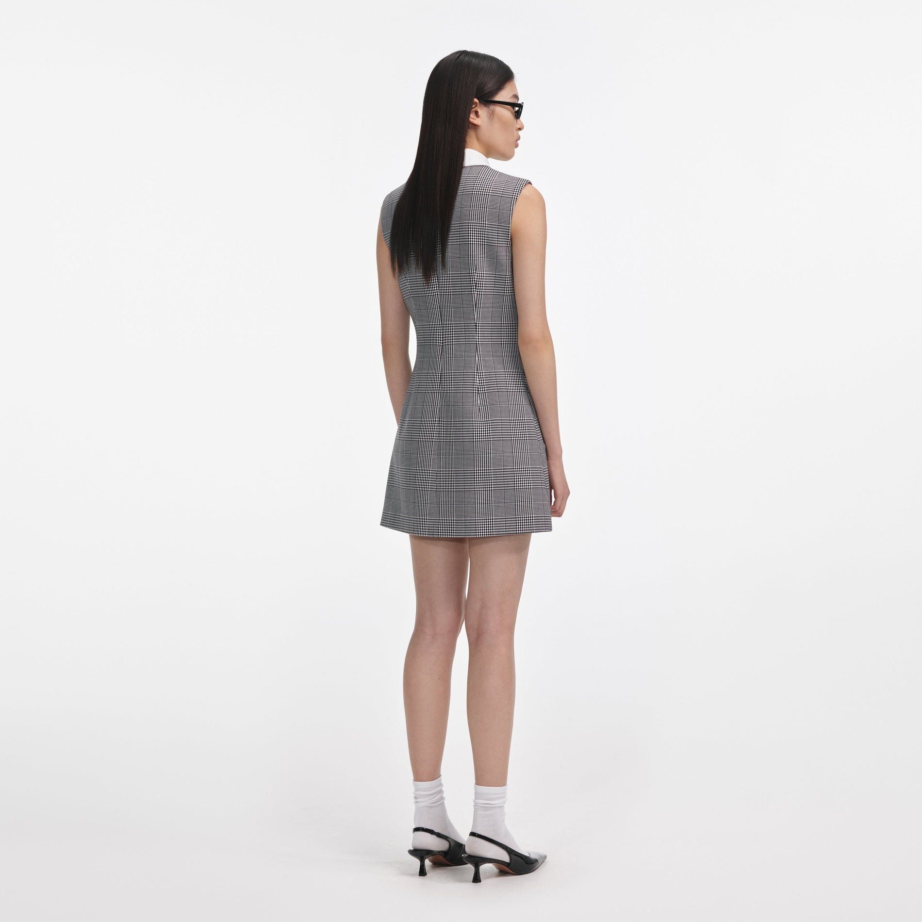 Back view of a woman wearing the Sleeveless Prince Of Wales Check Mini Dress