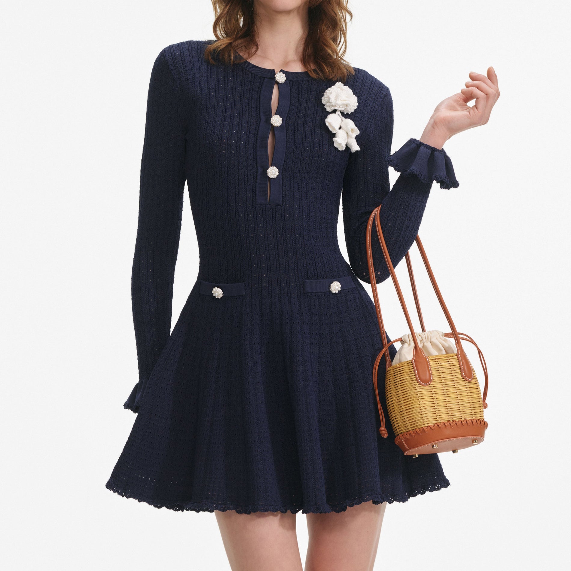 A close up of a woman wearing the Navy Pointelle Knit Crochet Flower Mini Dress