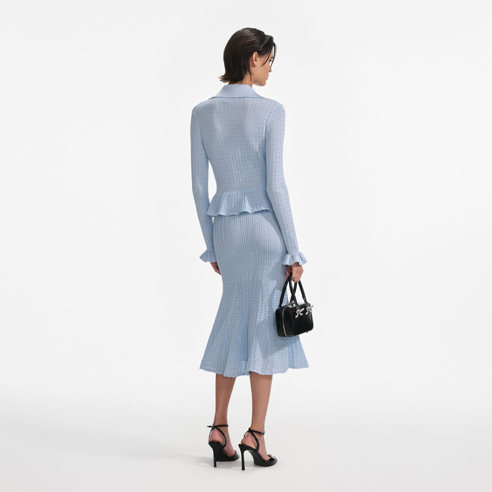 Back view of a woman wearing the Blue Pointelle Knit Midi Dress