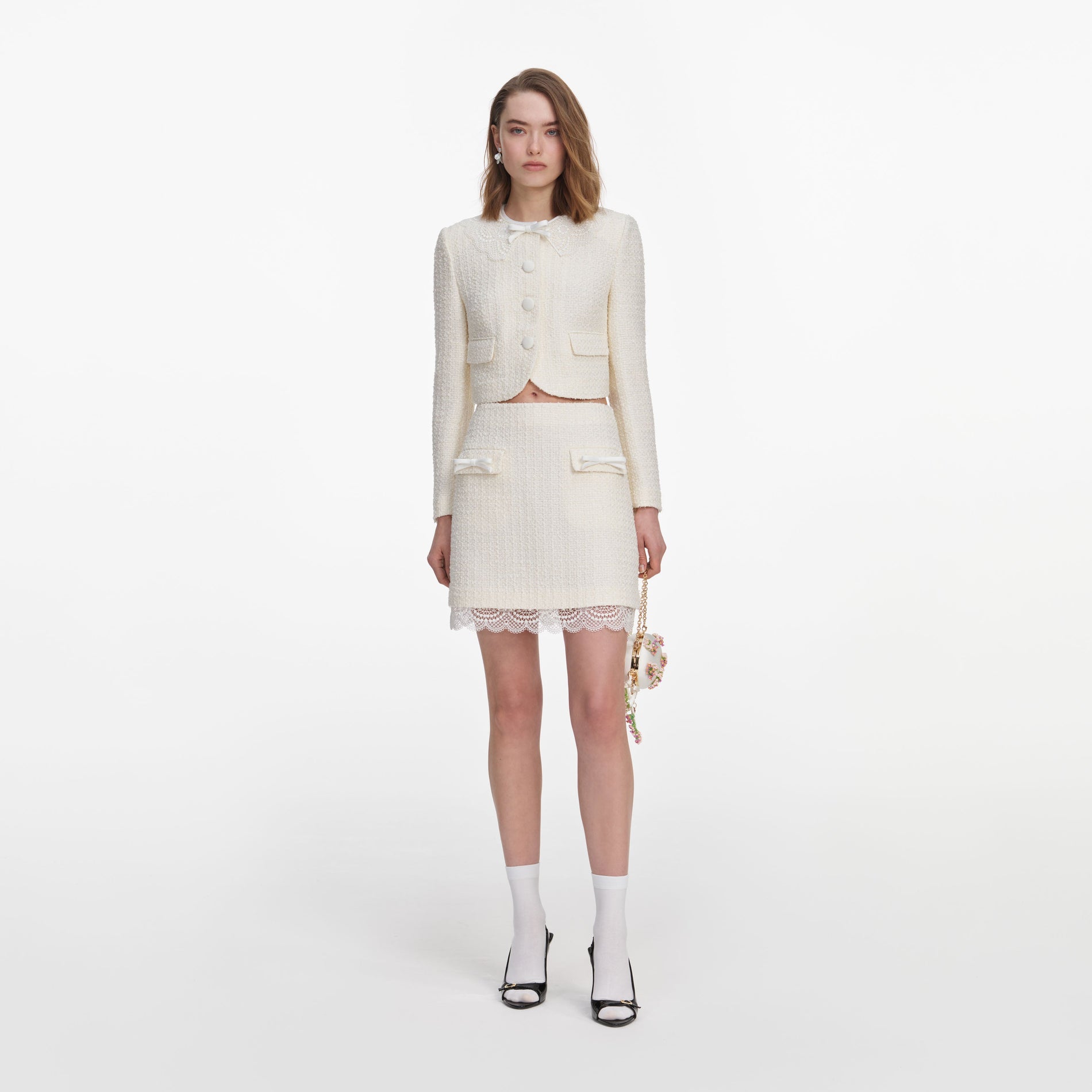 Front view of a woman wearing the Cream Boucle Lace Mini Skirt