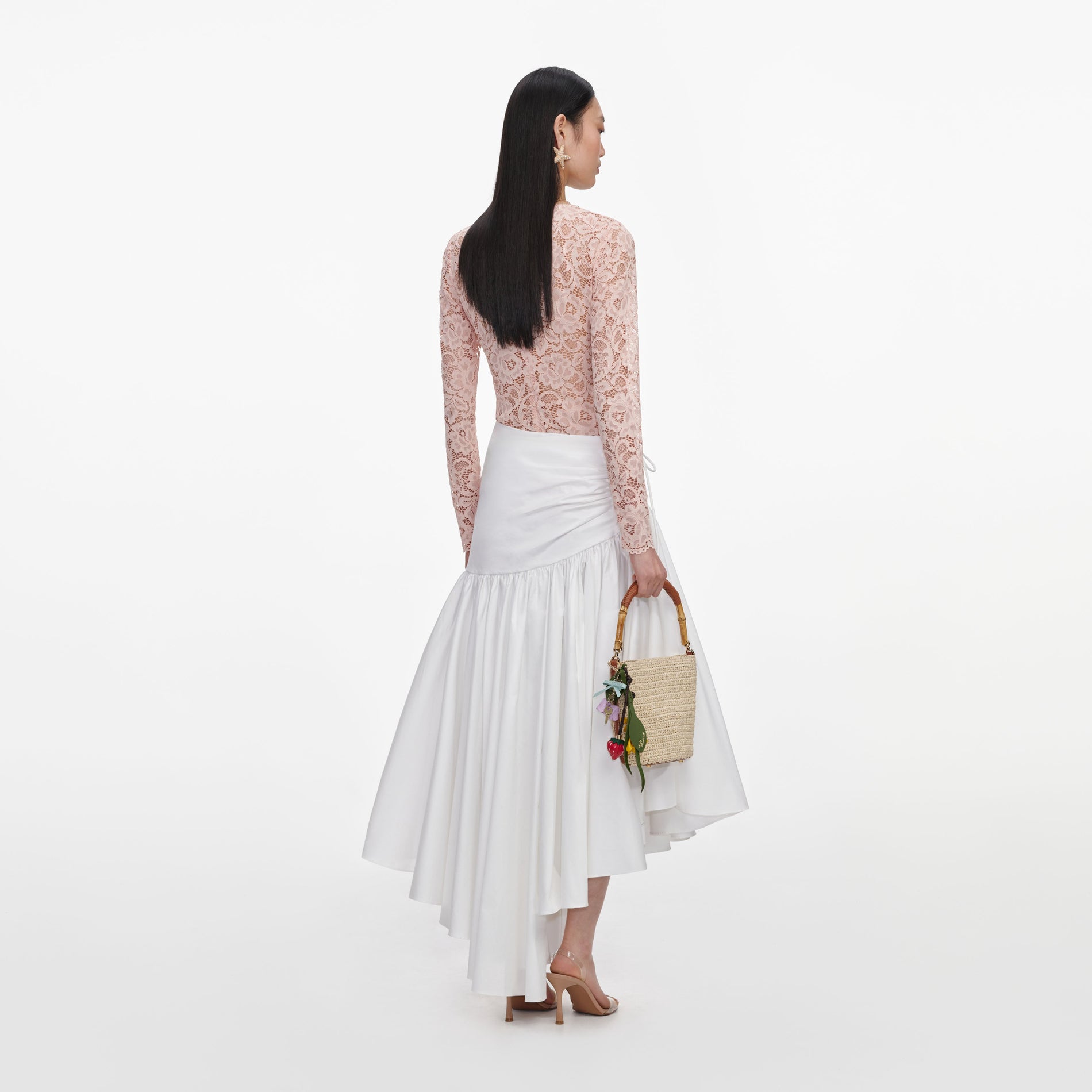 Back view of a woman wearing the White Cotton Asymmetric Midi Skirt