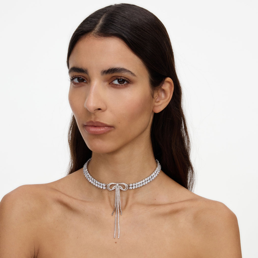 Woman with dark hair wearing a diamond choker with a bow and dangling strands