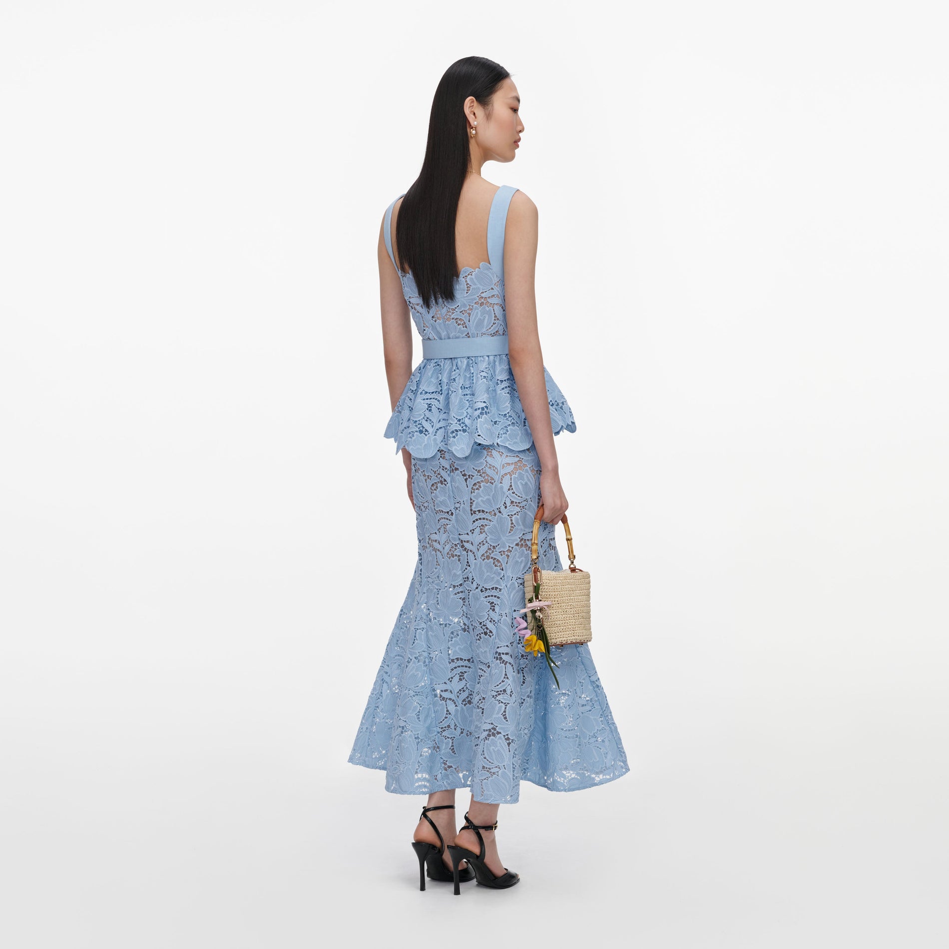Back view of a woman wearing the Blue Lace Peplum Midi Dress