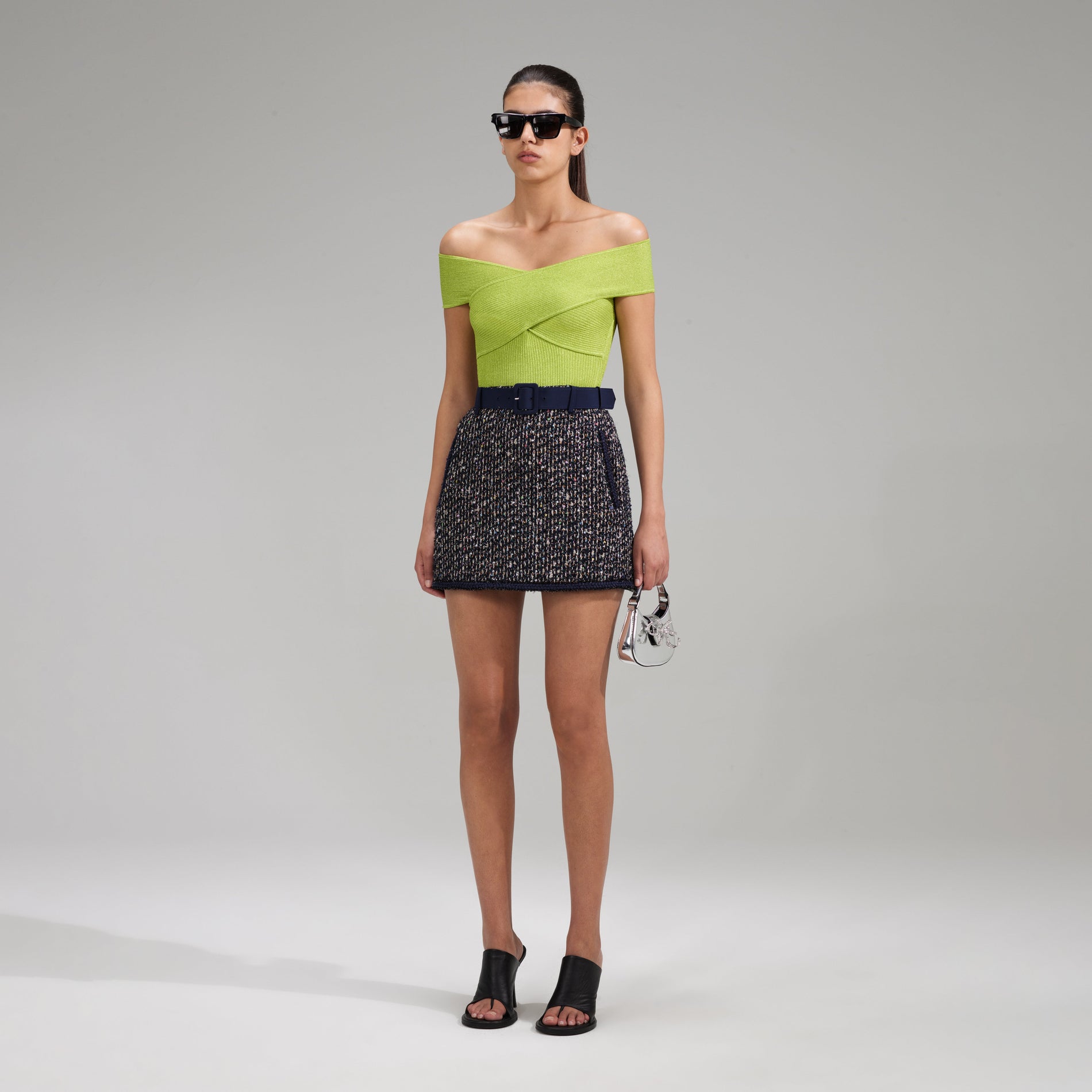 A woman wearing the Green Lurex Knit Off Shoulder Top