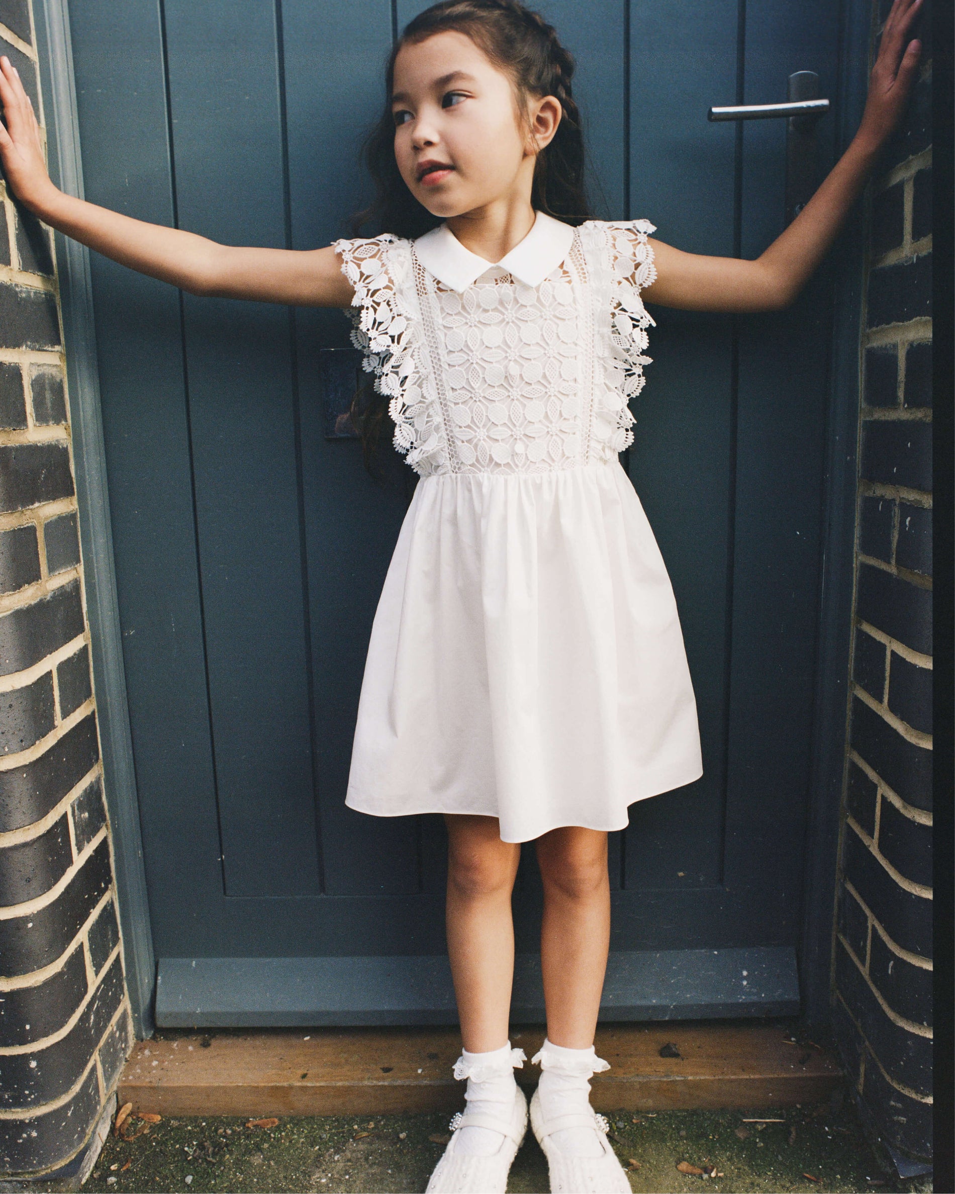 A woman wearing the White Lace Mini Dress