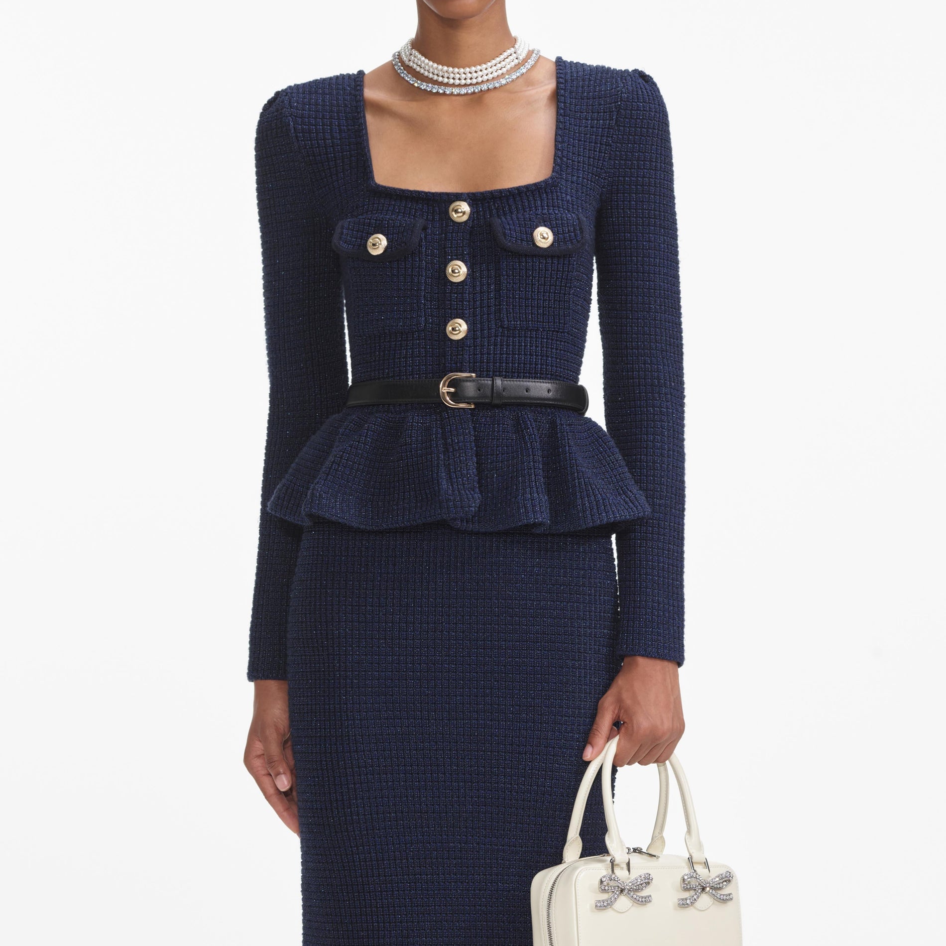 A close up of a woman wearing the Navy Knit Peplum Midi Dress