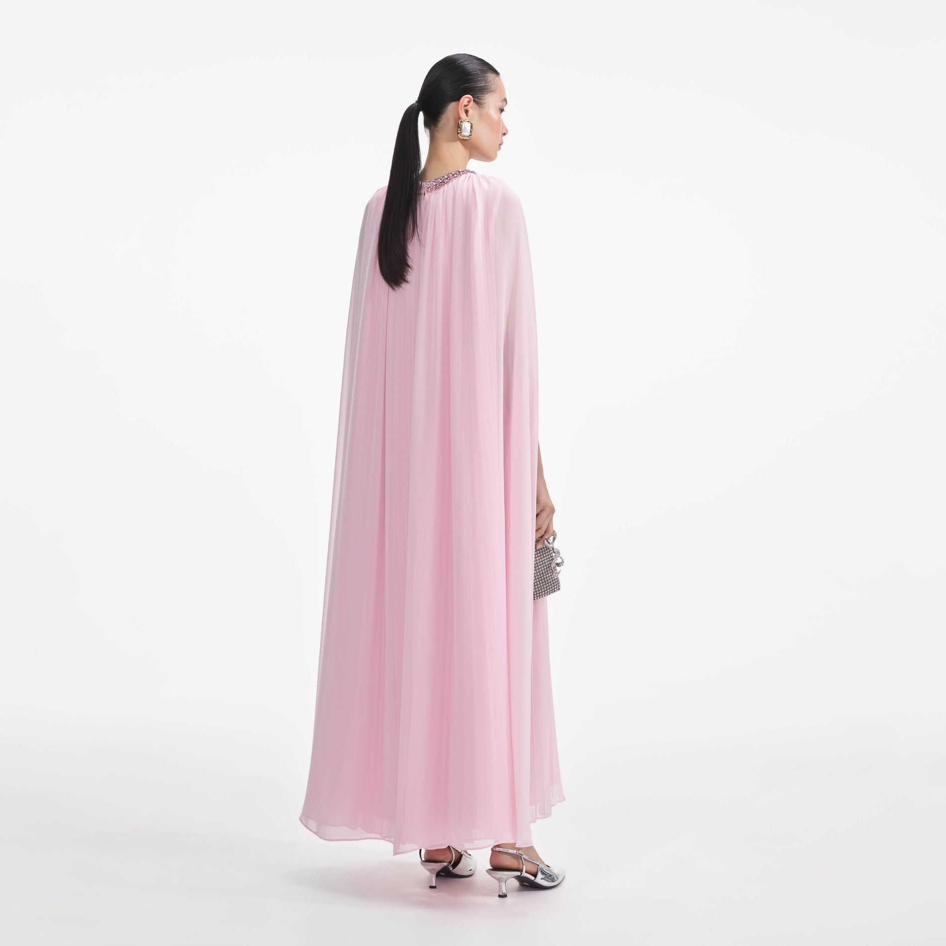 Back view of a woman wearing the Pink Chiffon Cape Midi Dress