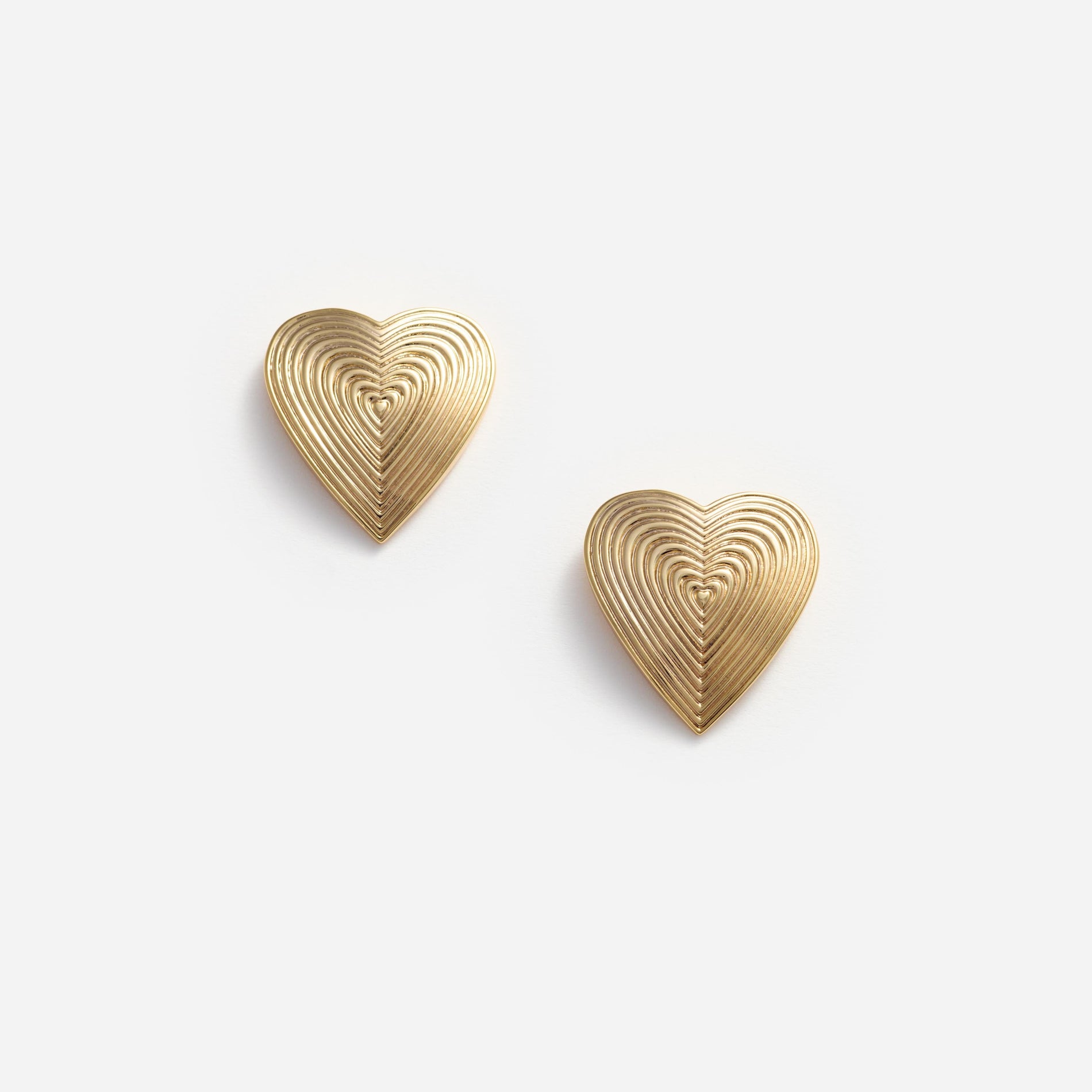 Front view of a woman wearing the Gold Heart Ridged Earrings