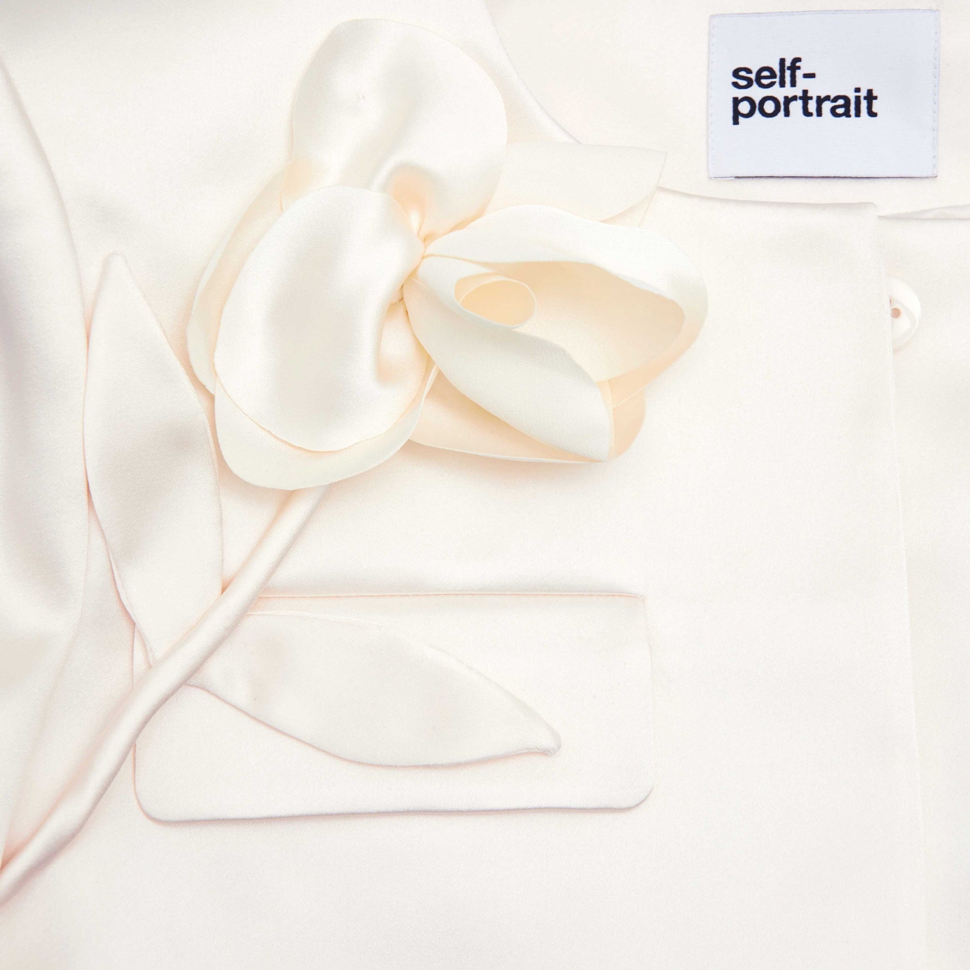 A close up of the fabric for the Cream 3D Flower Satin Jacket