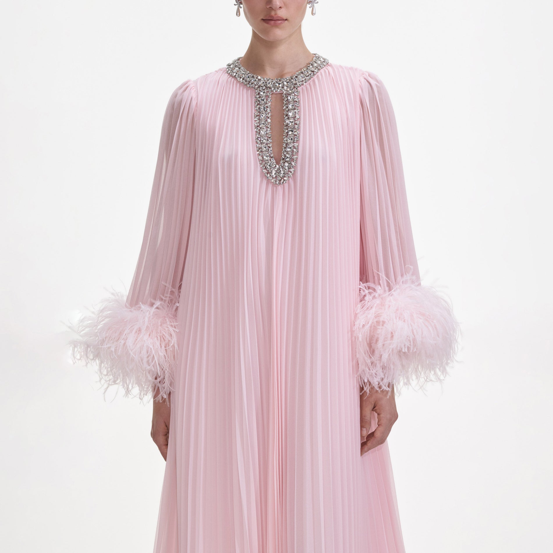 A close up of a woman wearing the Pink Chiffon Feather Midi Dress