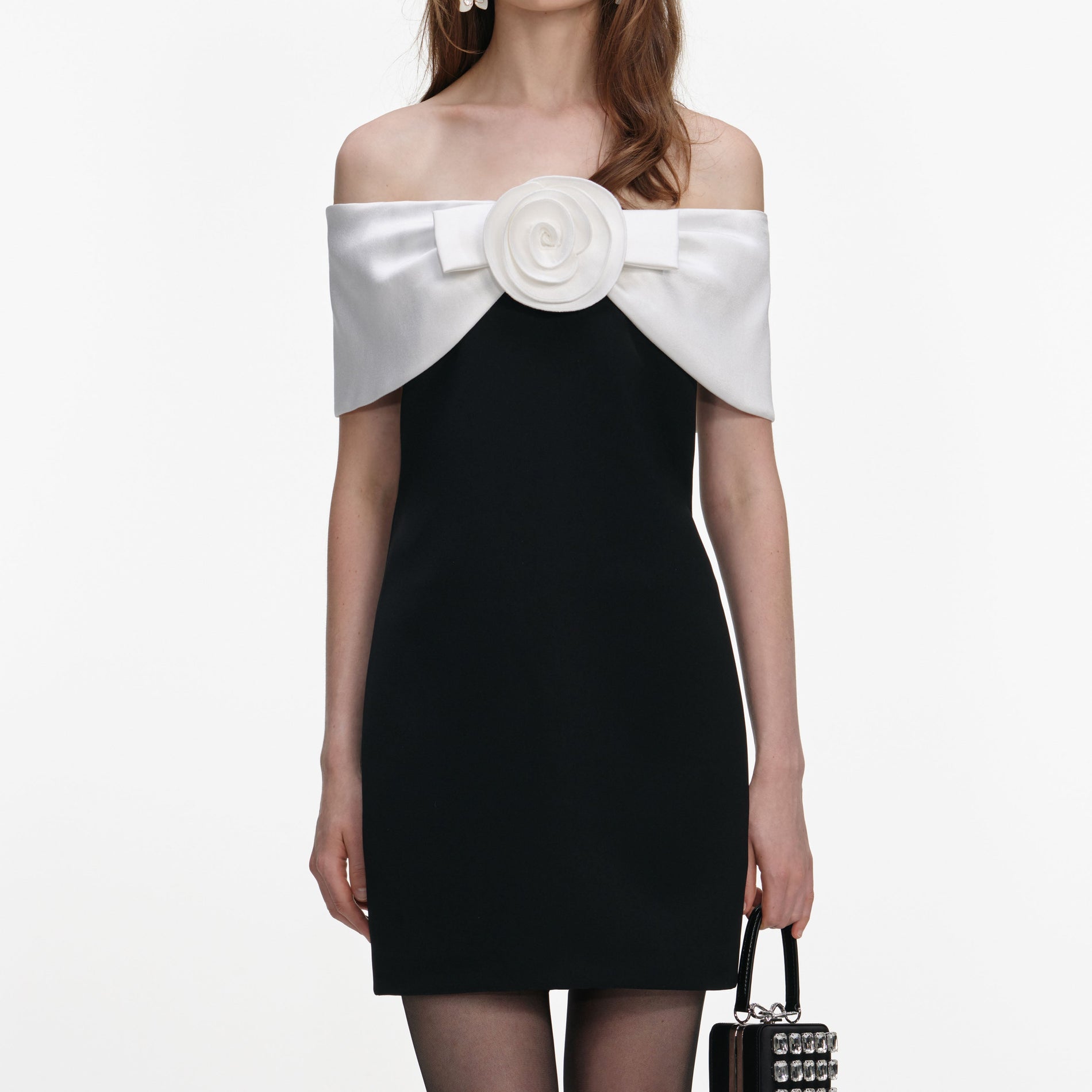 A close up of a woman wearing the Black Crepe Flower Mini Dress