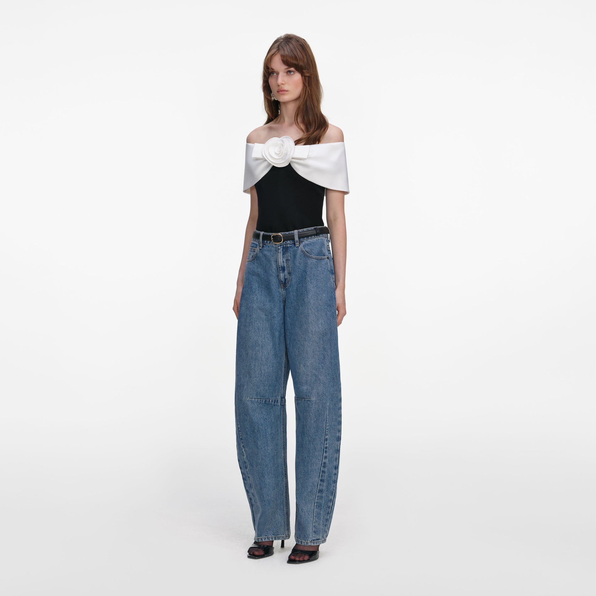 Side view of a woman wearing the Black Crepe Flower Top