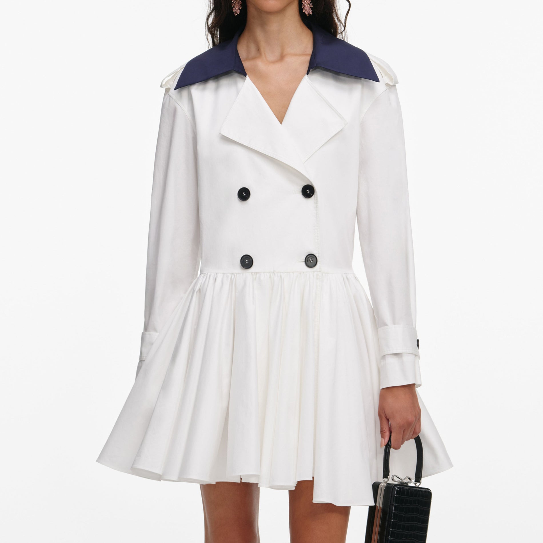 A close up of a woman wearing the White Cotton Double Breasted Mini Dress