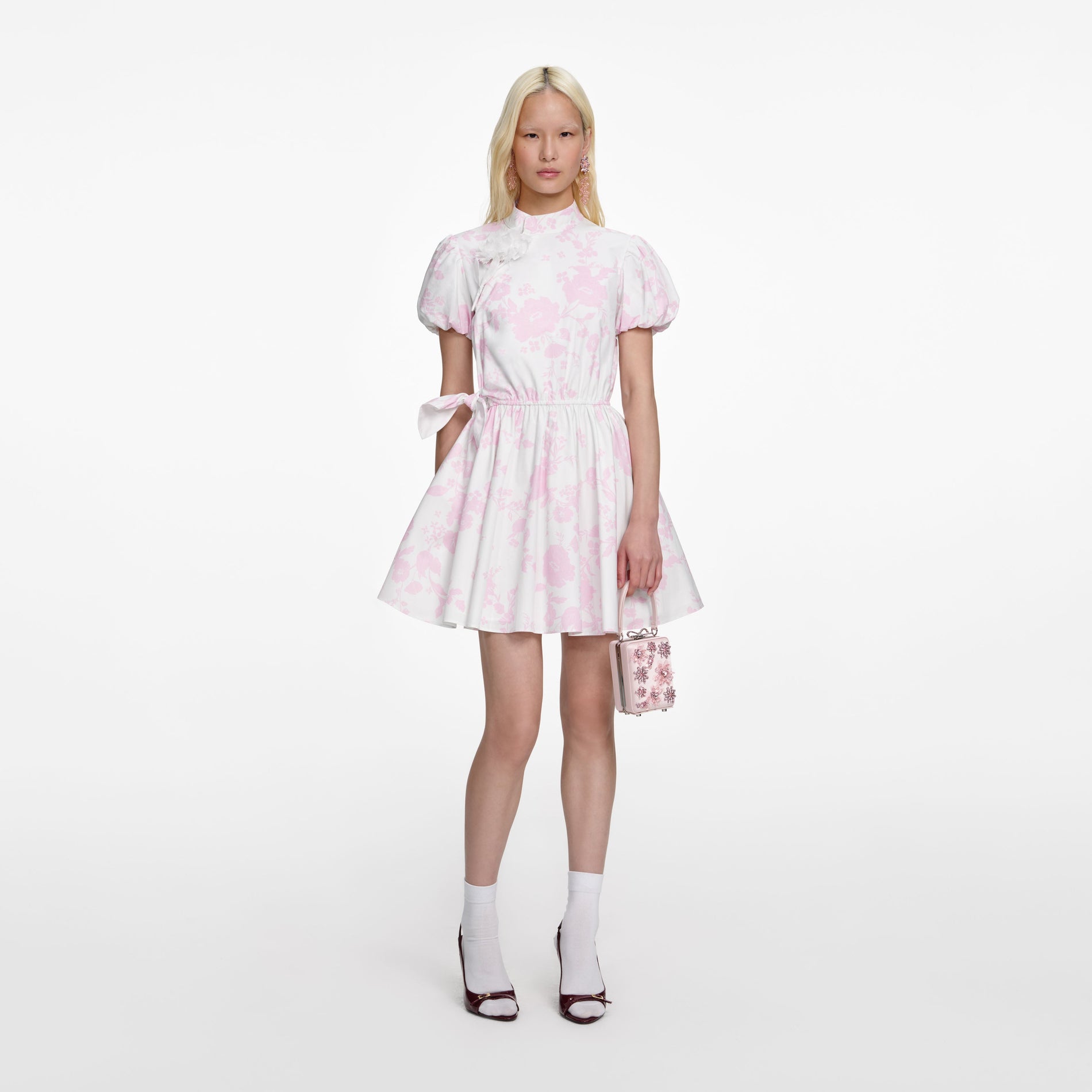 Front view of a woman wearing the Pink Floral Cotton Drape Mini Dress