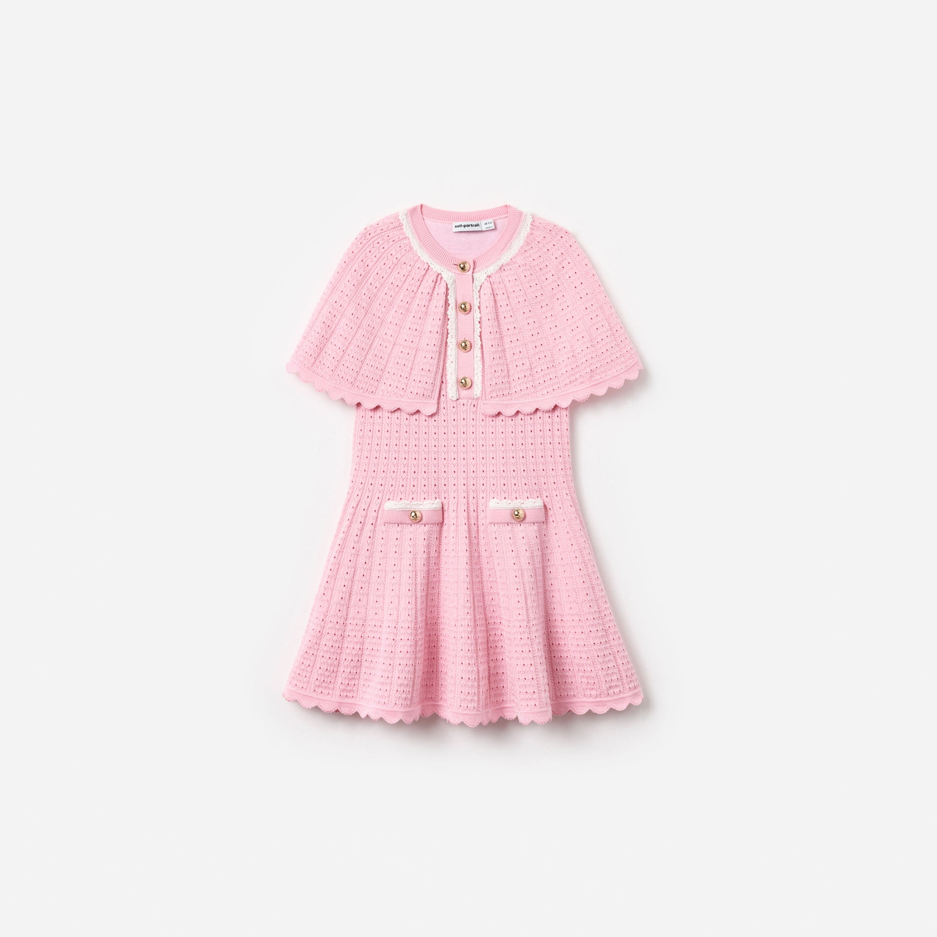 Pink knit dress with short capelet sleeves, white trim, gold buttons, and two front pockets