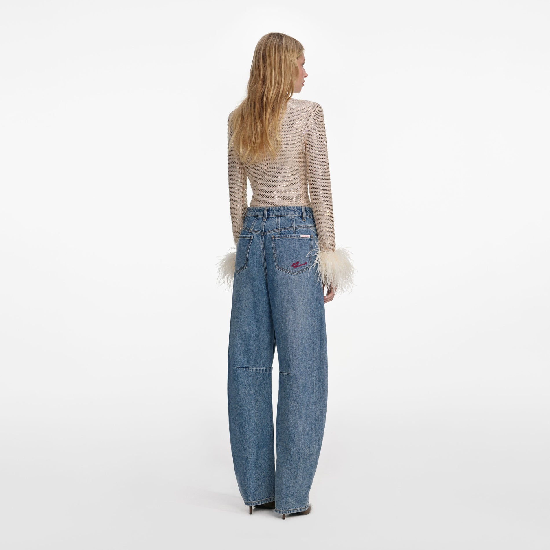 Back view of a woman wearing the Champagne Rhinestone Feather Top