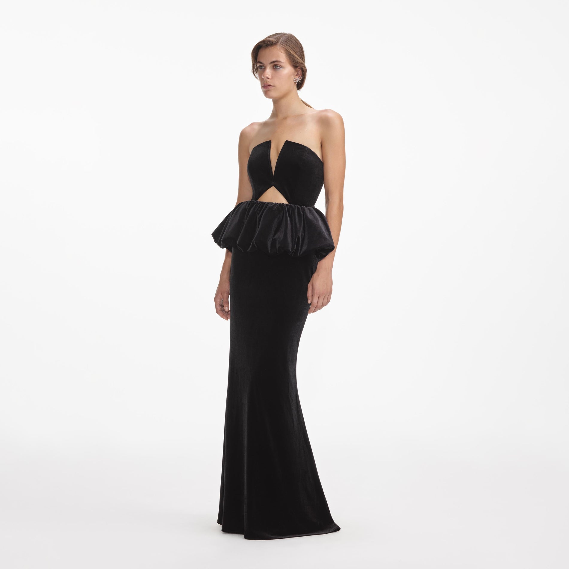Side view of a woman wearing the Black Velvet Peplum Maxi Dress