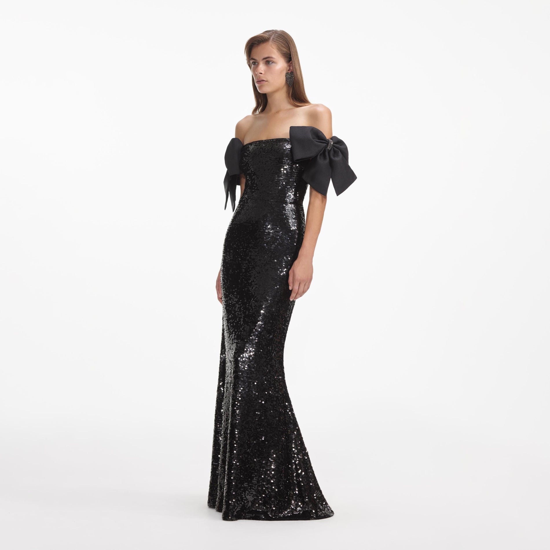 Side view of a woman wearing the Black Sequin Bow Maxi Dress