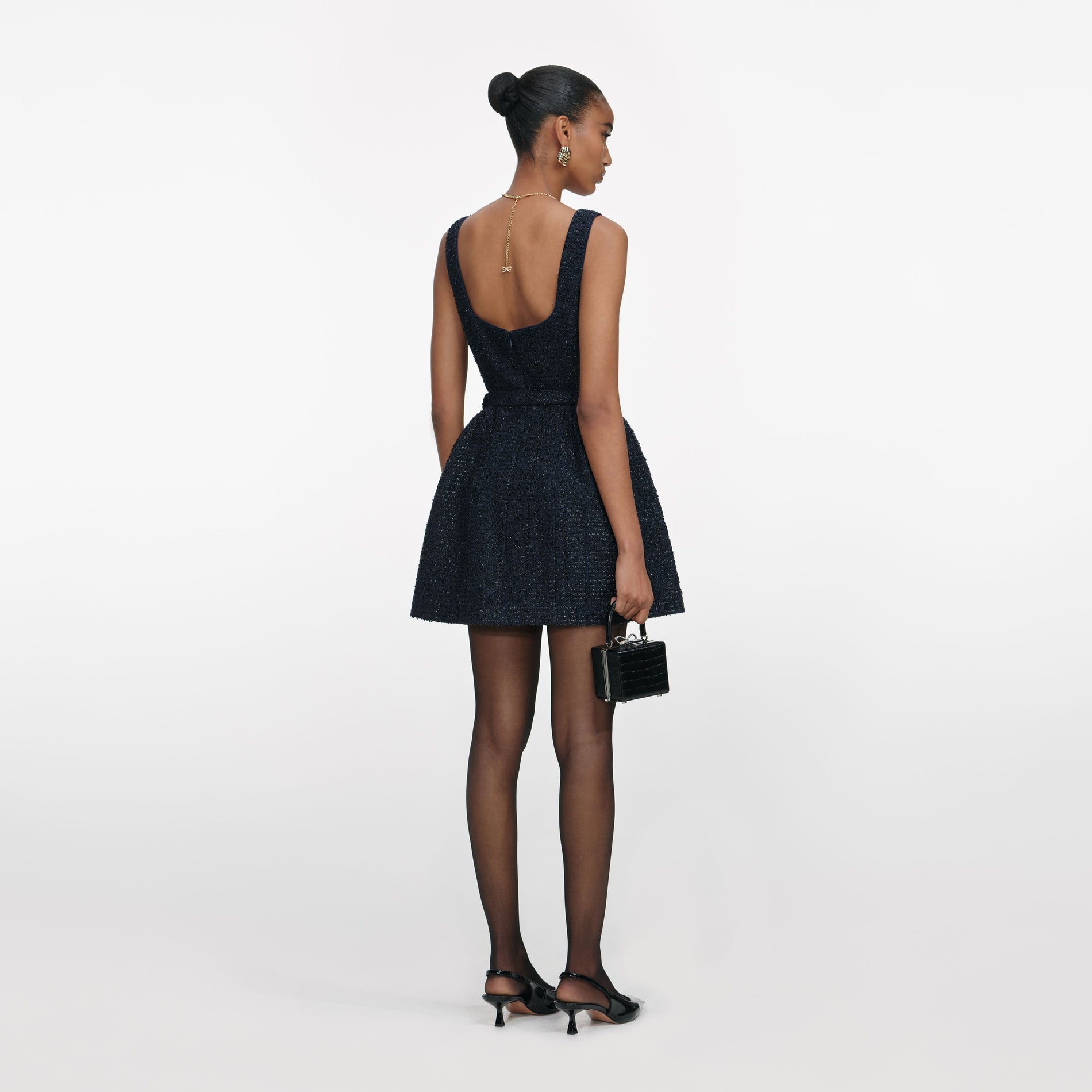 Back view of a woman wearing the Navy Boucle Sleeveless Mini Dress