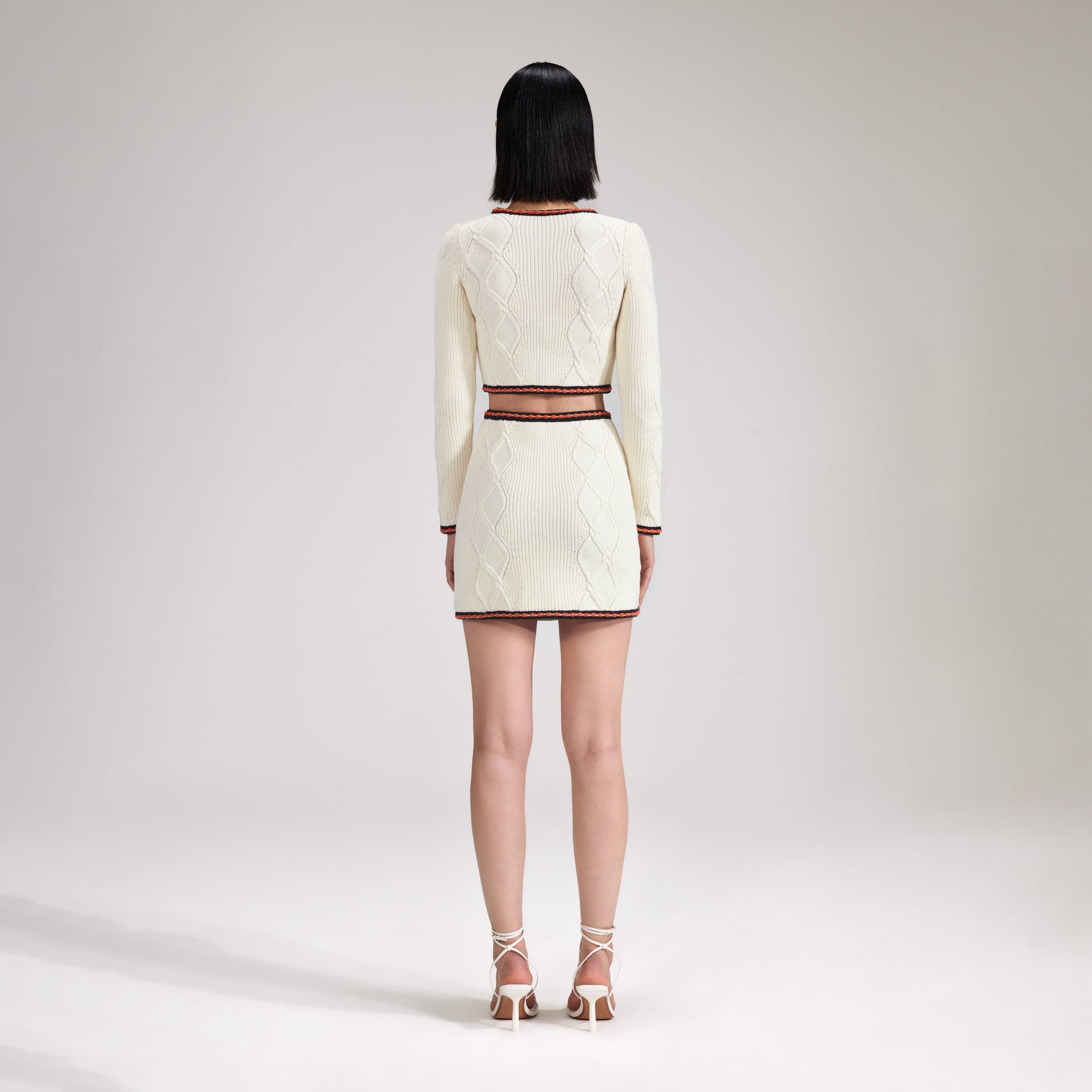 A woman wearing the Cream Cable Knit Skirt