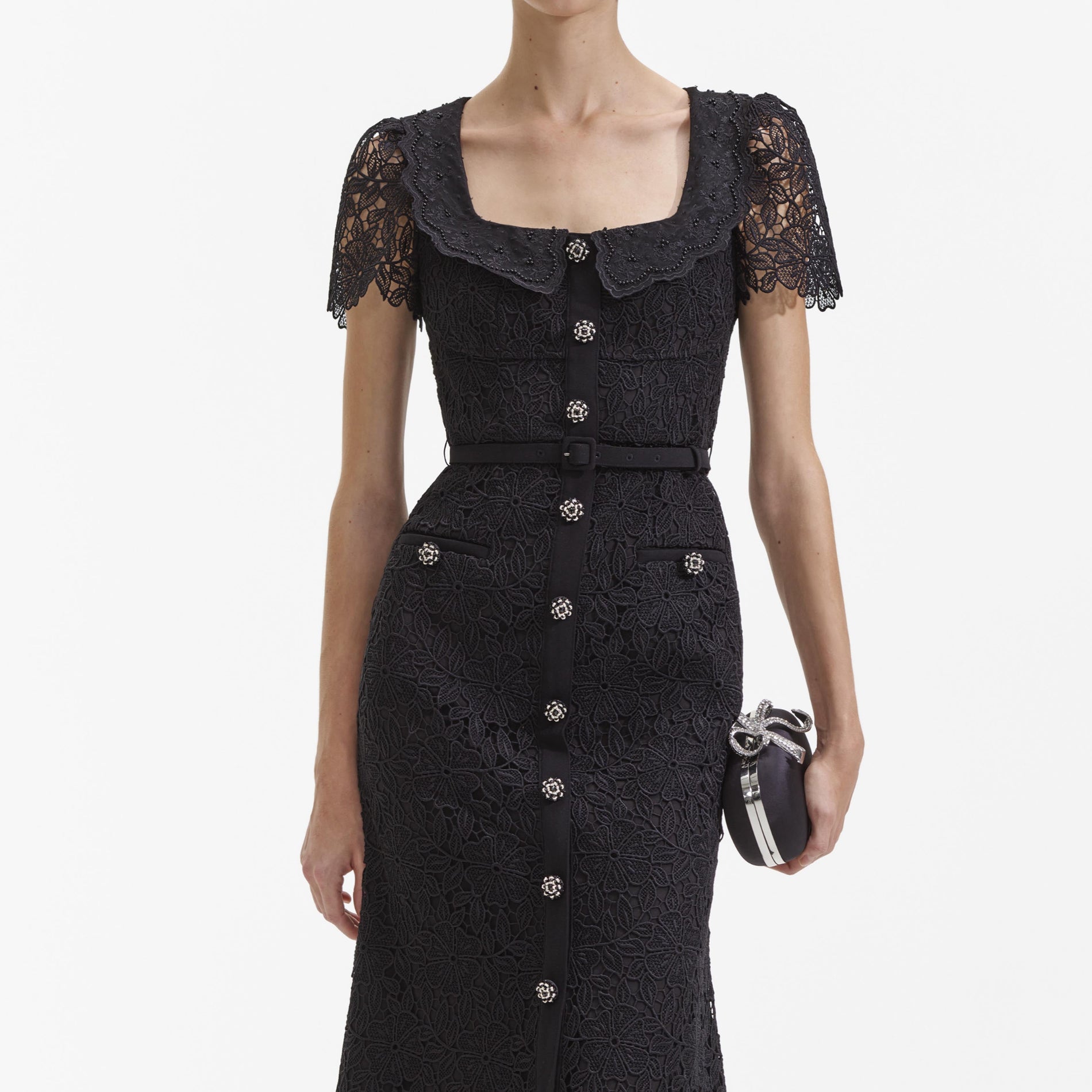 A close up of a woman wearing the Black Guipure Lace Button Midi Dress