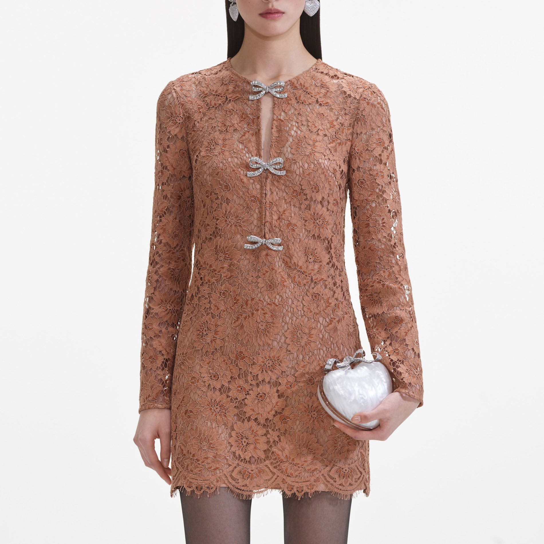 A close up of a woman wearing the Tan Lace Bow Mini Dress