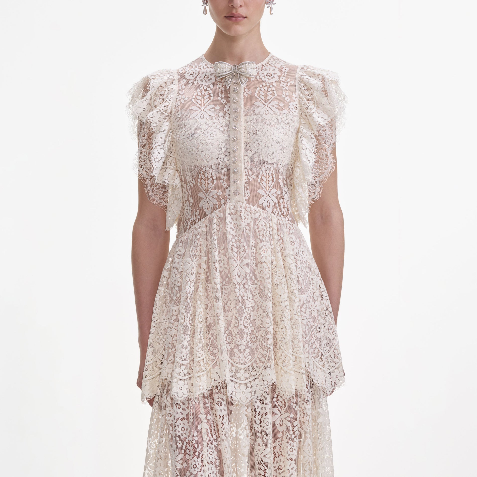 A close up of a woman wearing the White Tiered Lace Maxi Dress