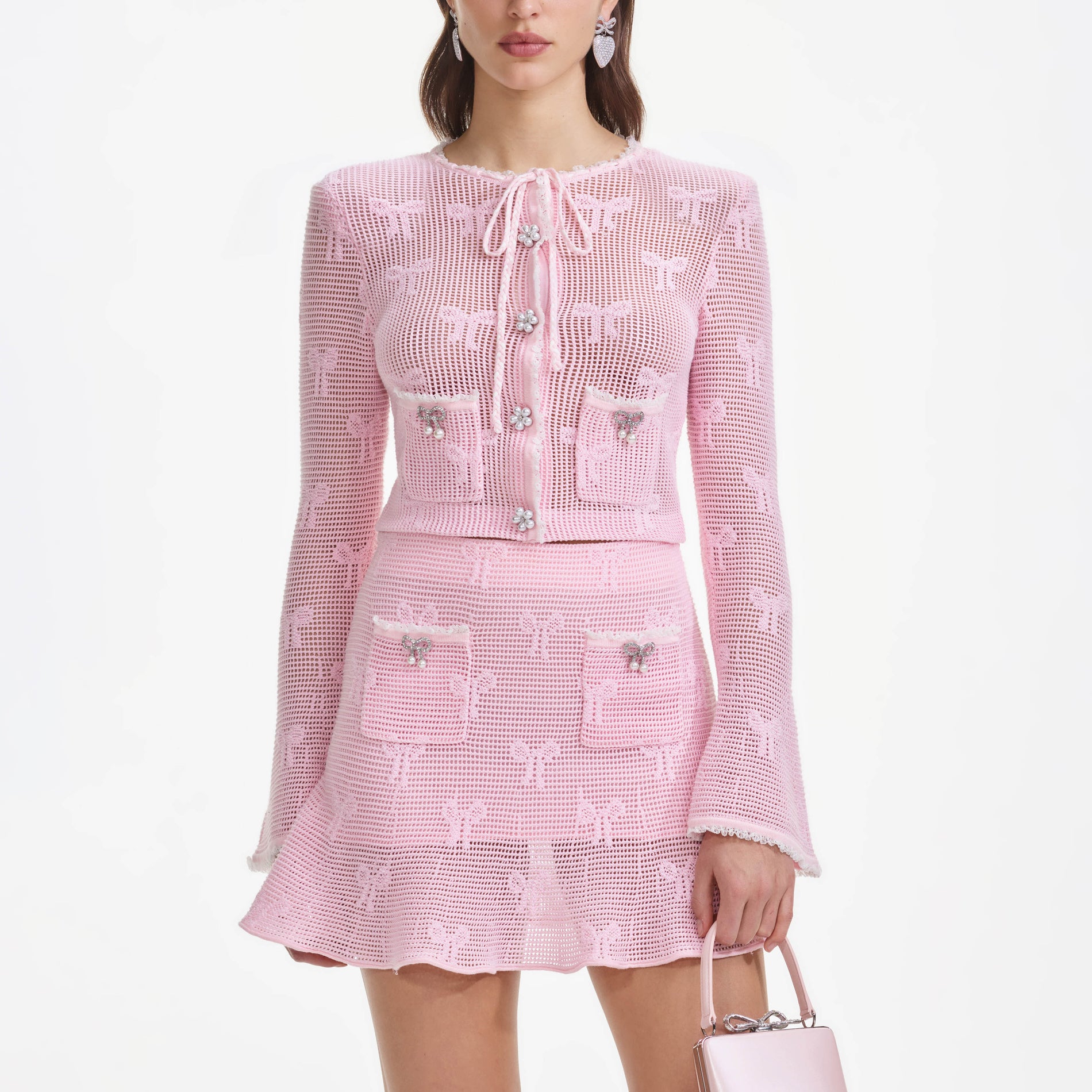 A close up of a woman wearing the Pink Bow Crochet Cardigan