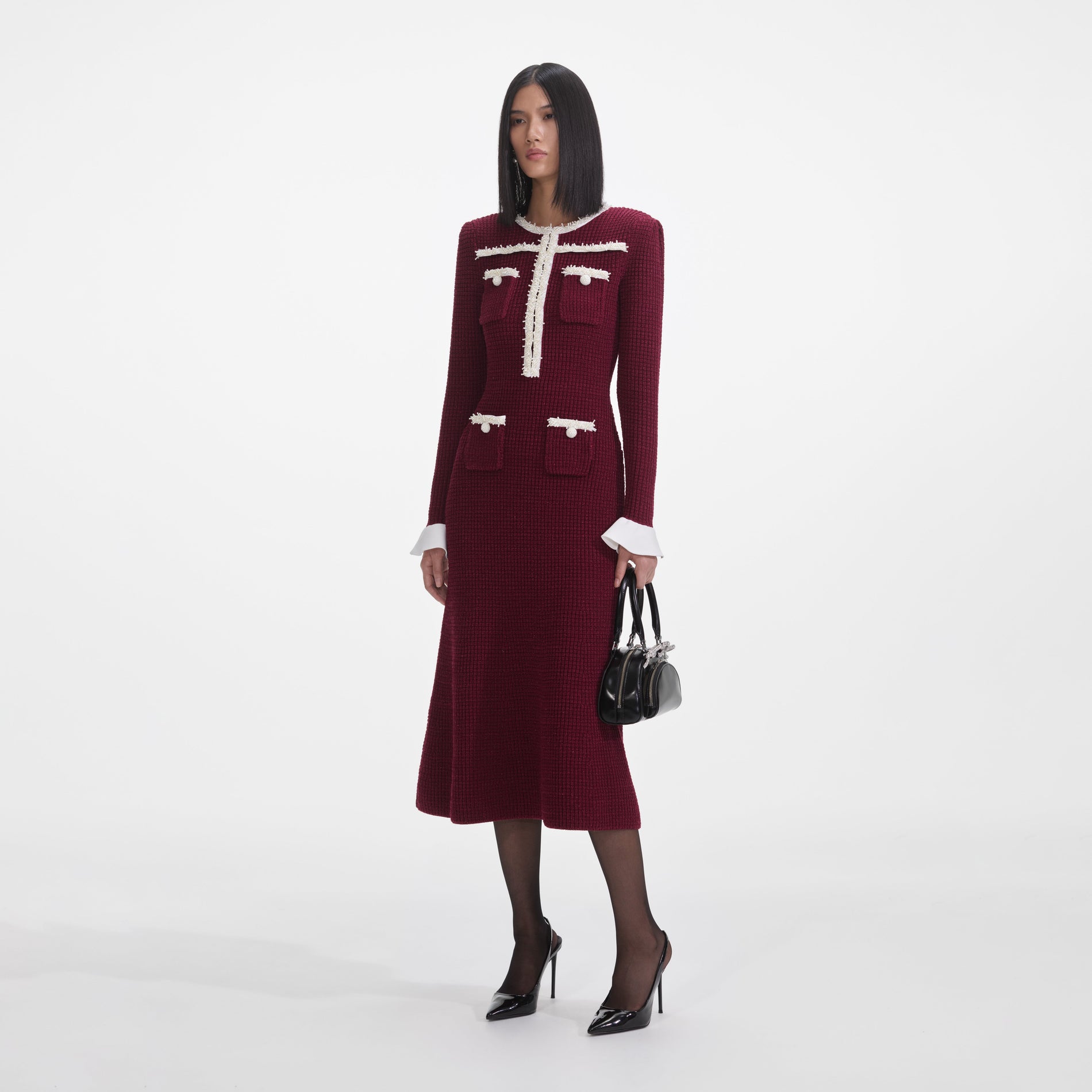 Side view of a woman wearing the Burgundy Pearl Trim Knit Midi Dress