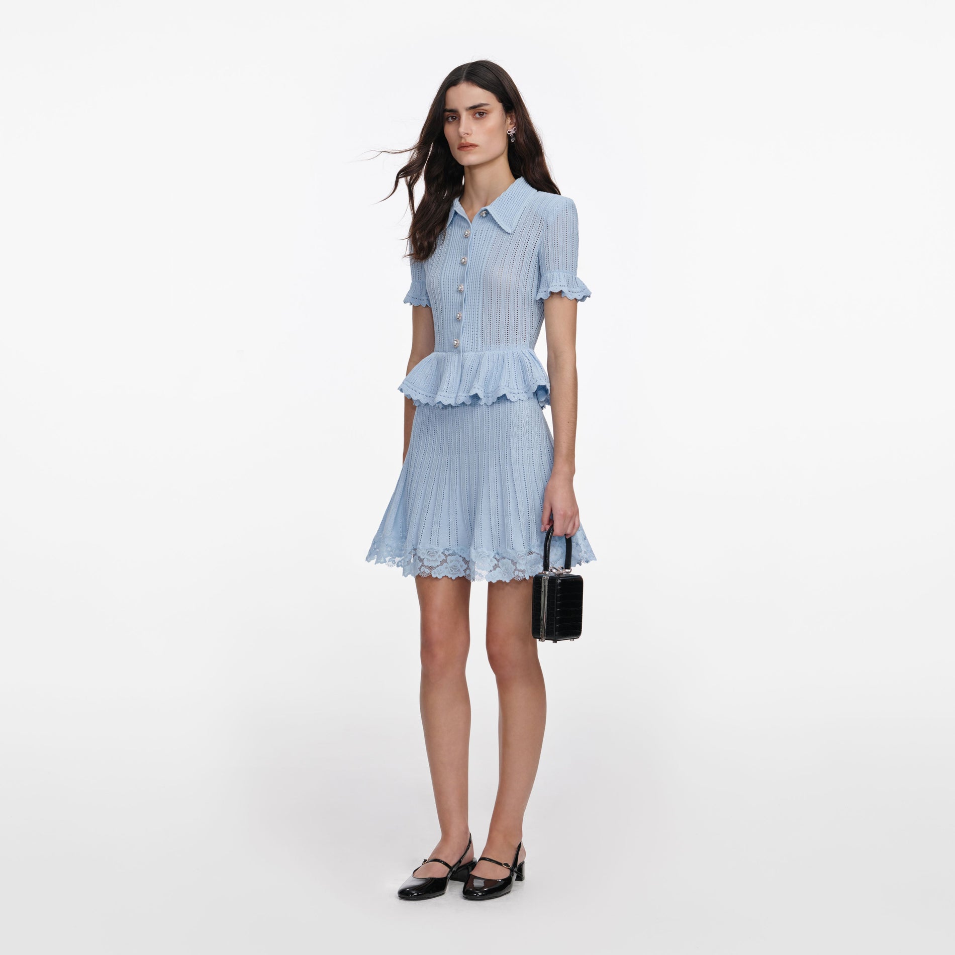 Side view of a woman wearing the Blue Pointelle Peplum Knit Mini Dress