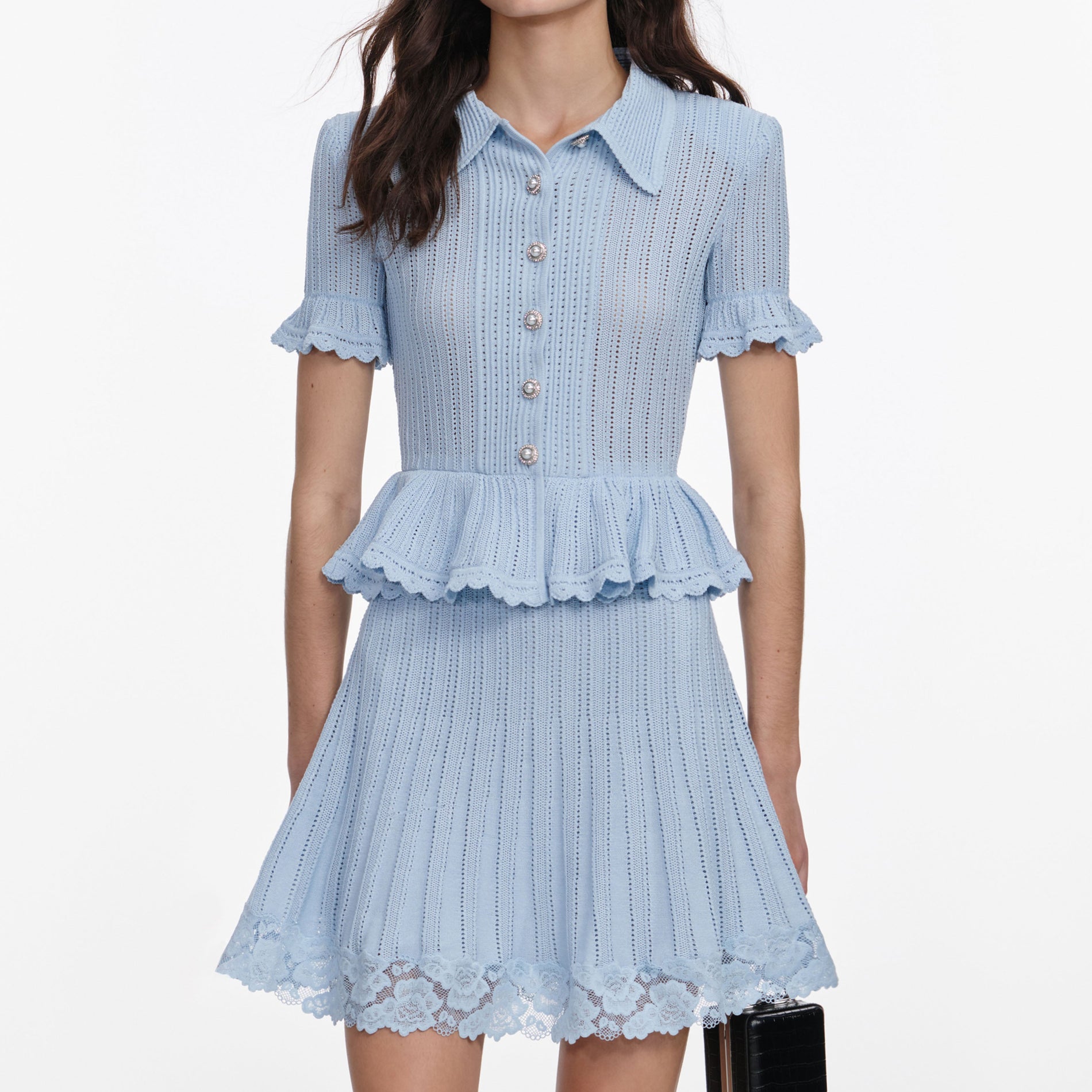 A close up of a woman wearing the Blue Pointelle Peplum Knit Mini Dress