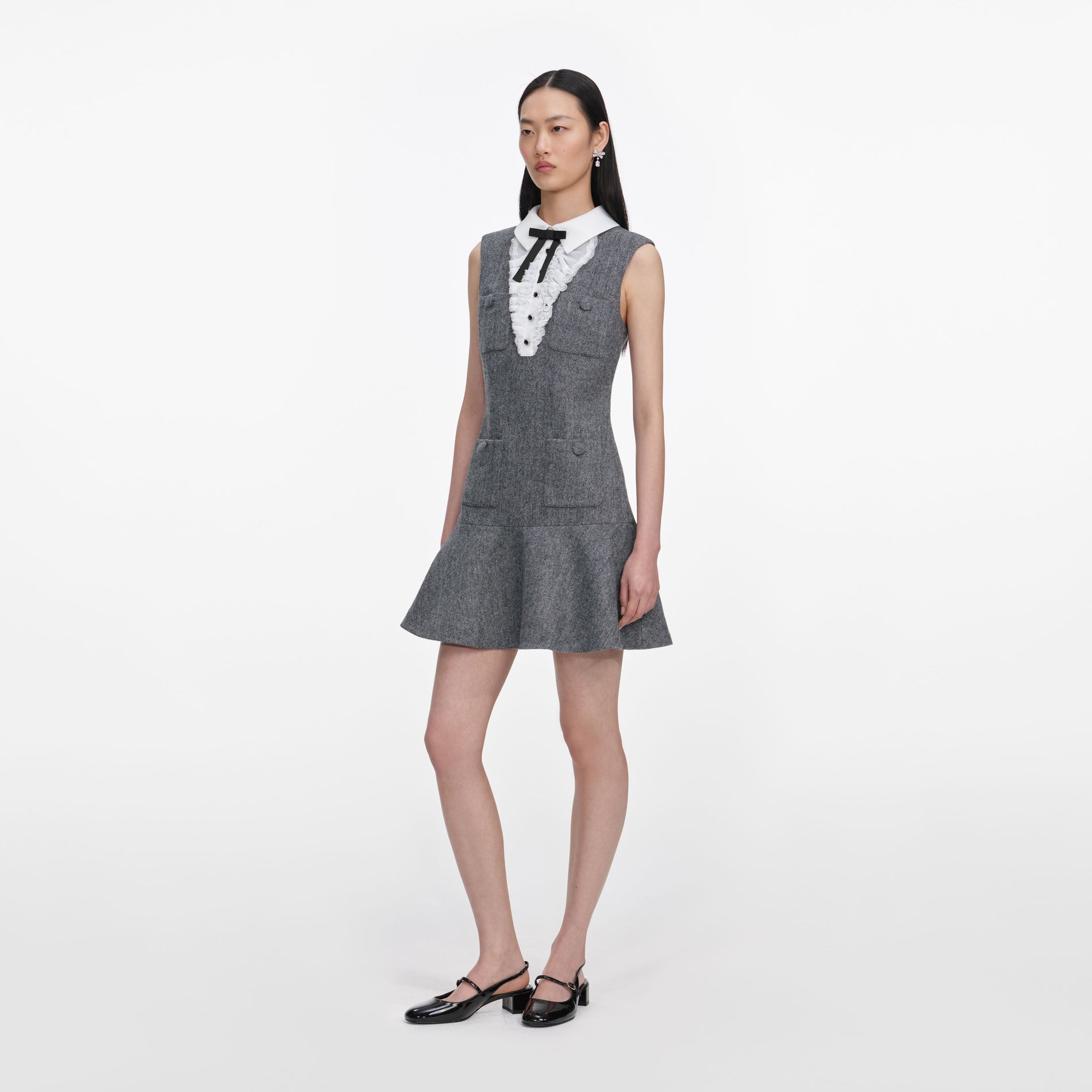 Side view of a woman wearing the Grey Herringbone Lace Bib Mini Dress