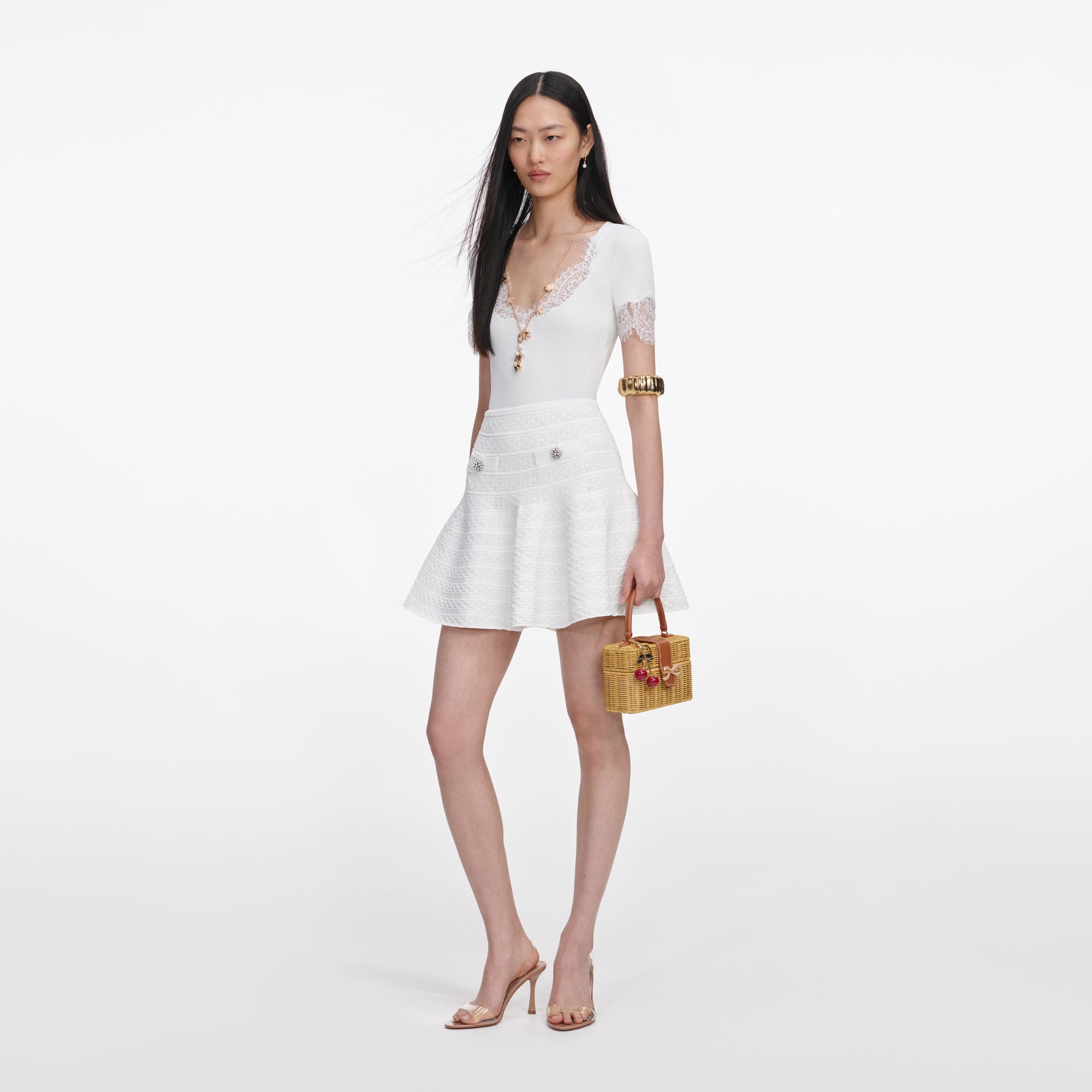 Side view of a woman wearing the White Lace Trim Knit Bodysuit