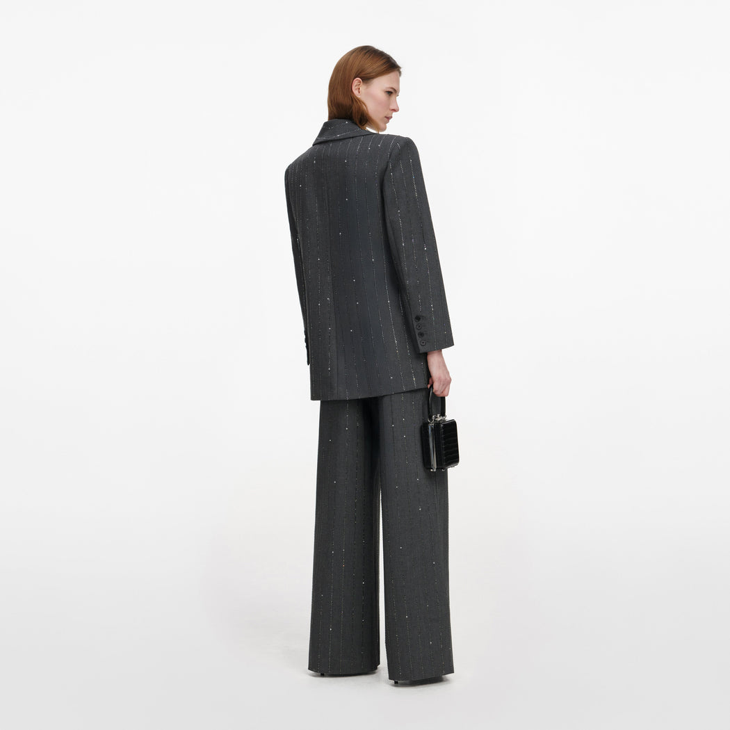 Back view of a woman wearing the Grey Rhinestone Pinstripe Trousers