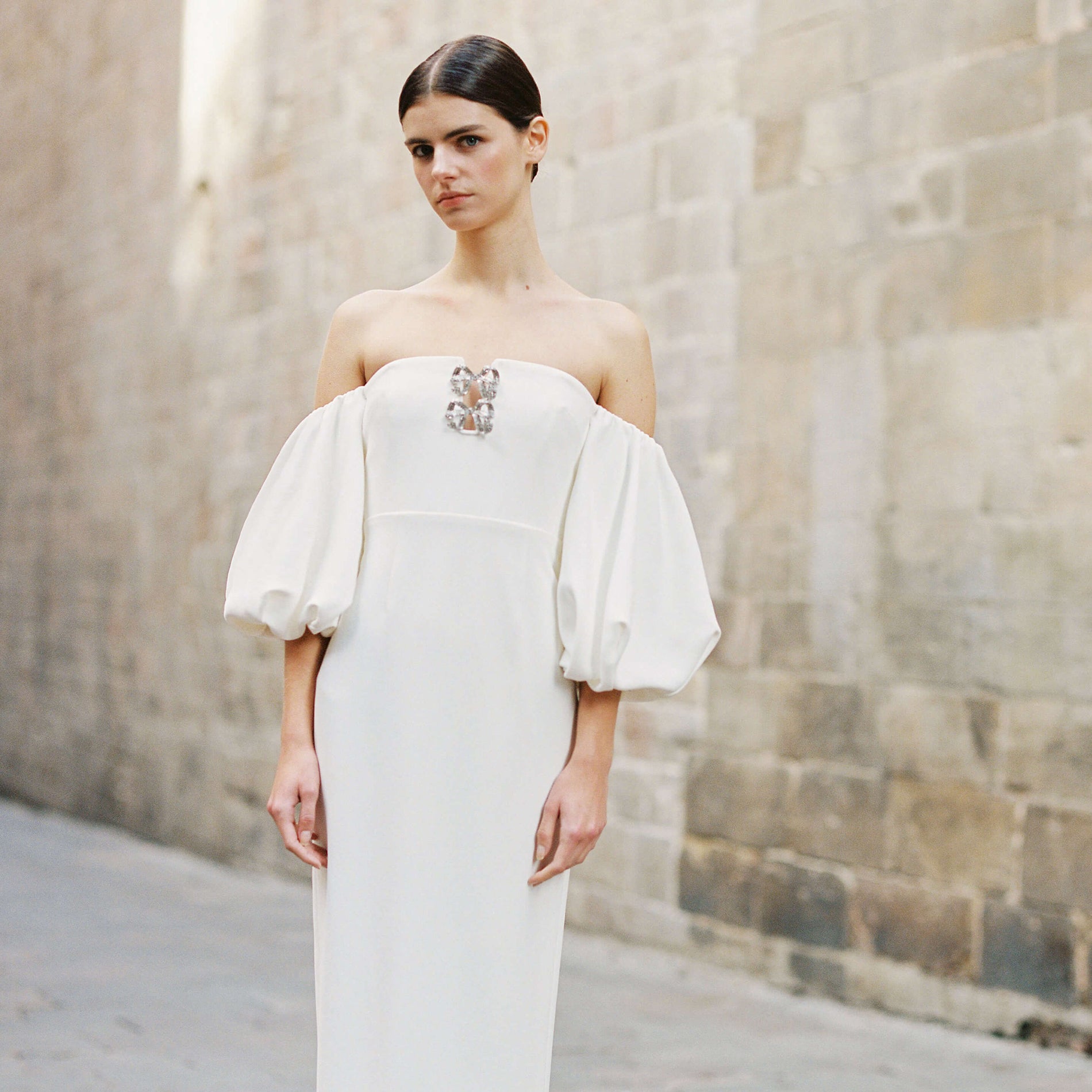 A woman wearing the White Crepe Bow Midi Dress